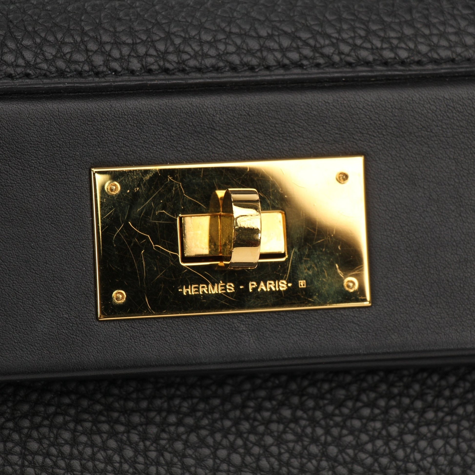 Hermès Top Handle Clemence handbag in beige leather with gold-tone hardware and structured design.