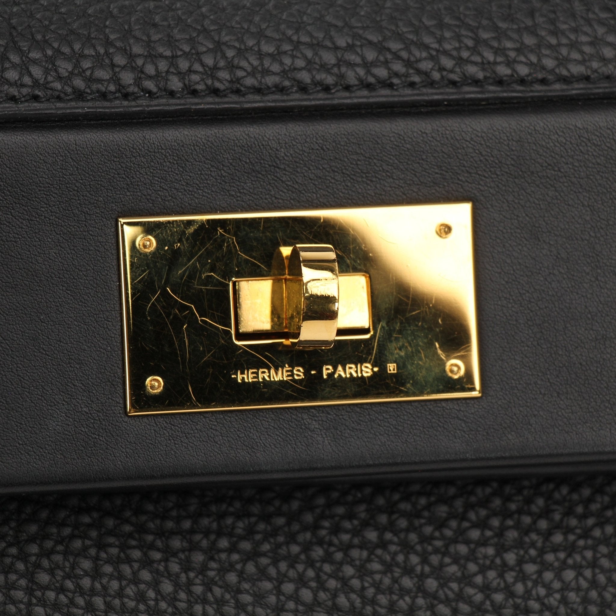 Hermès Top Handle Clemence handbag in beige leather with gold-tone hardware and structured design.