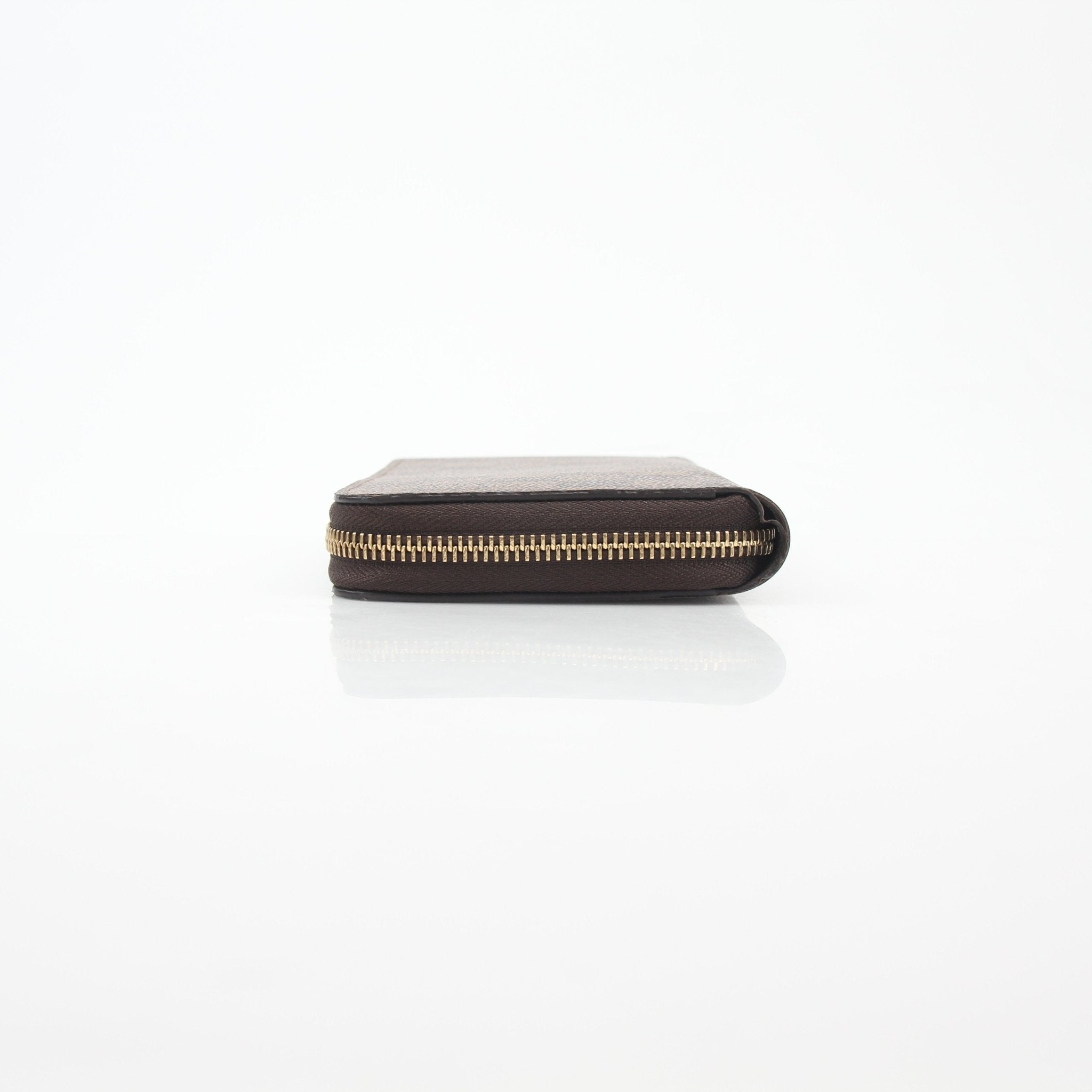 Louis Vuitton Damier Ebene Zippy Wallet with gold hardware and multiple card slots, featuring signature checkered pattern.
