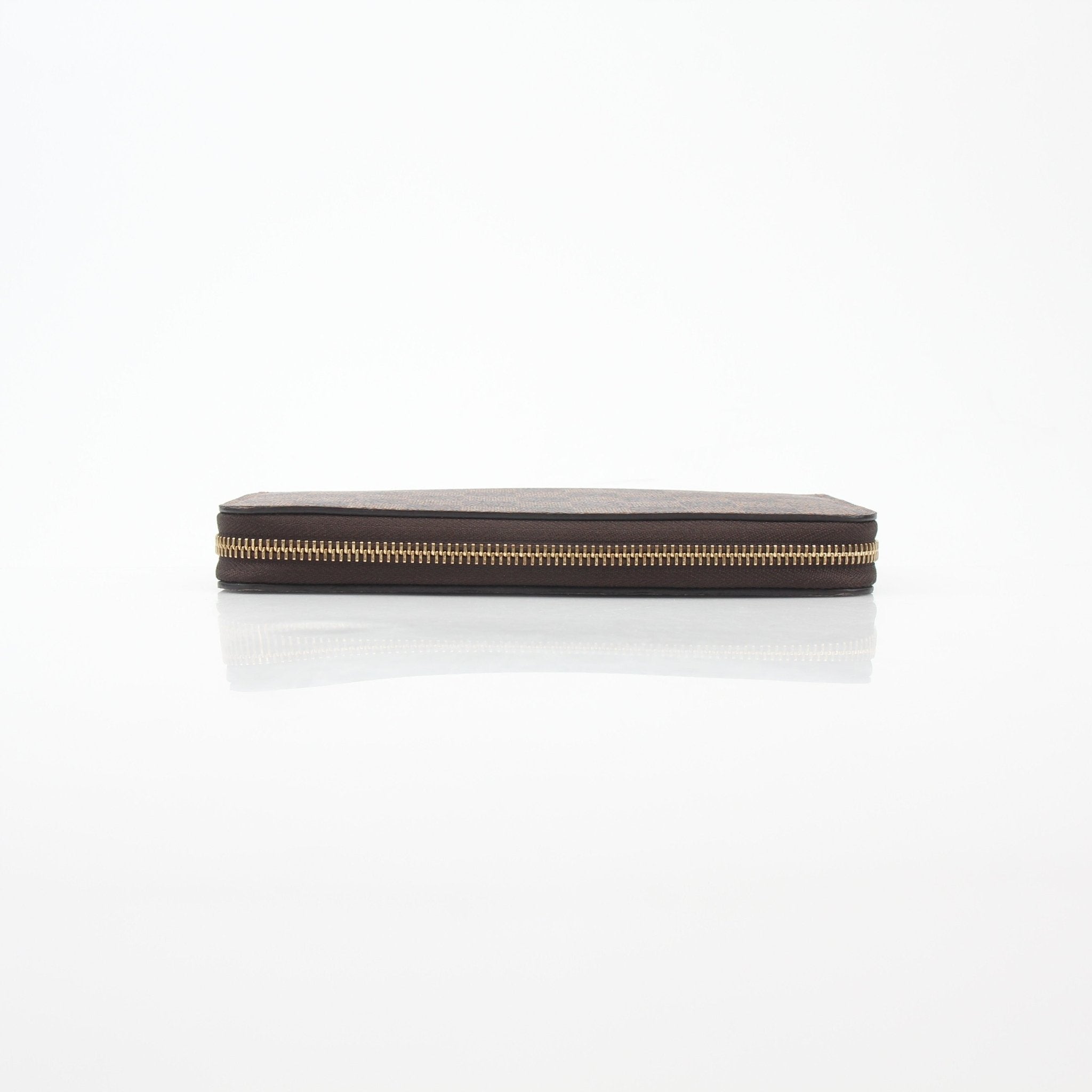Louis Vuitton Damier Ebene Zippy Wallet with gold accents, featuring checkered brown pattern and multiple card slots.