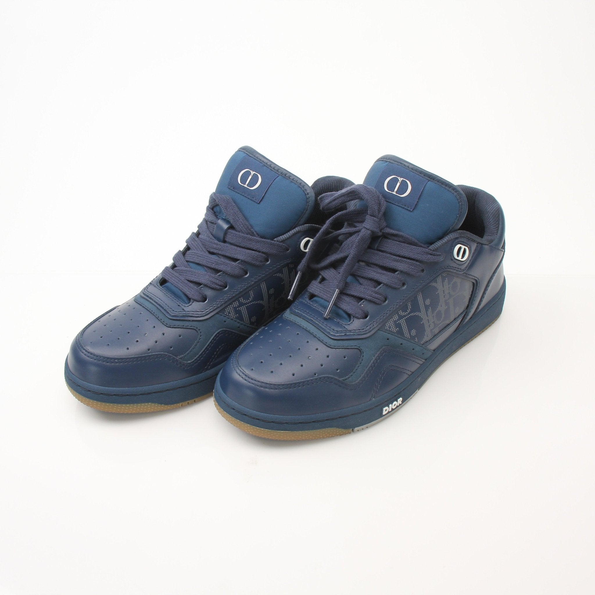 Christian Dior Navy Oblique Sneakers showing navy leather shoes with Dior's signature oblique pattern and white rubber soles.