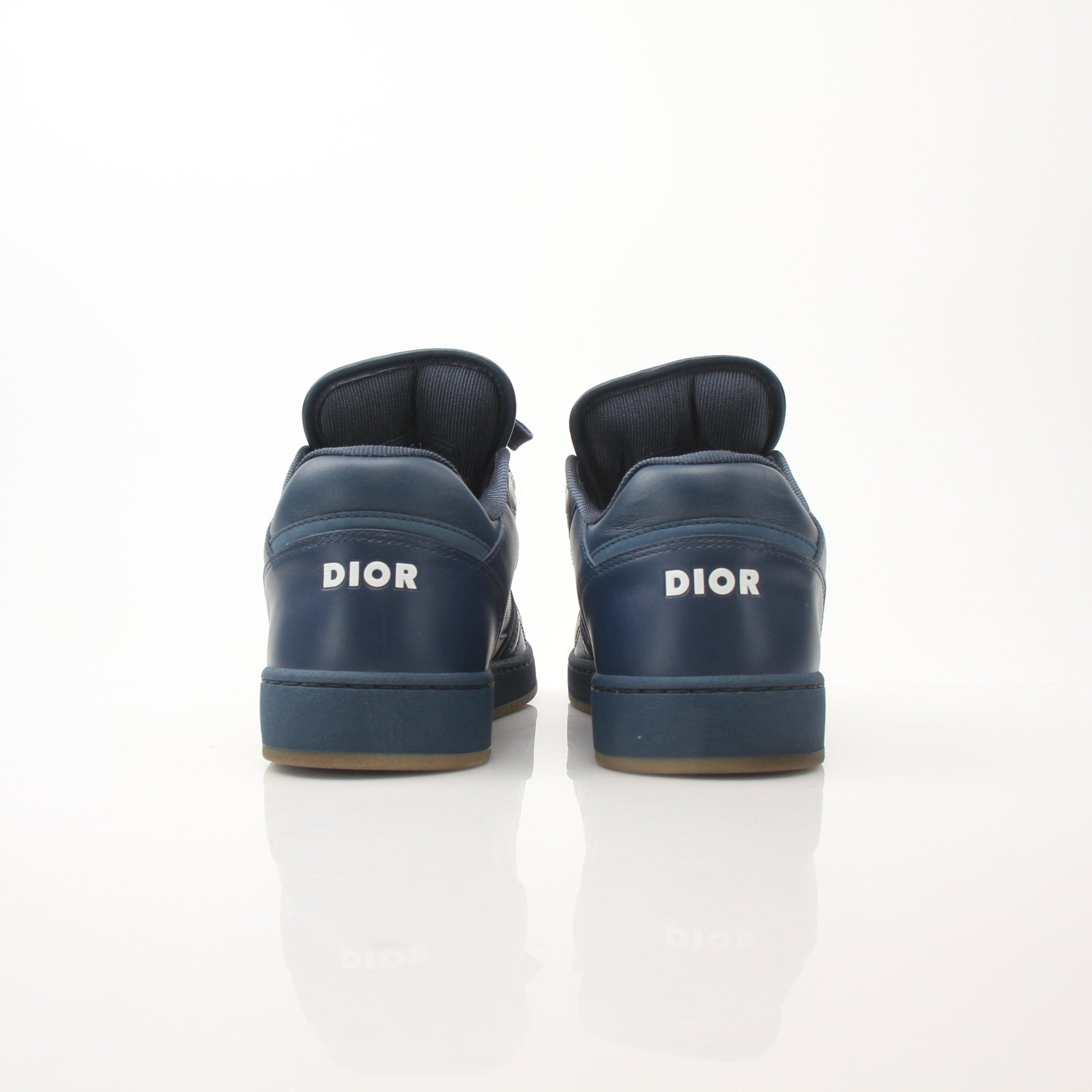 Christian Dior Navy Oblique sneakers with white soles and Dior branding, shown on a white background.