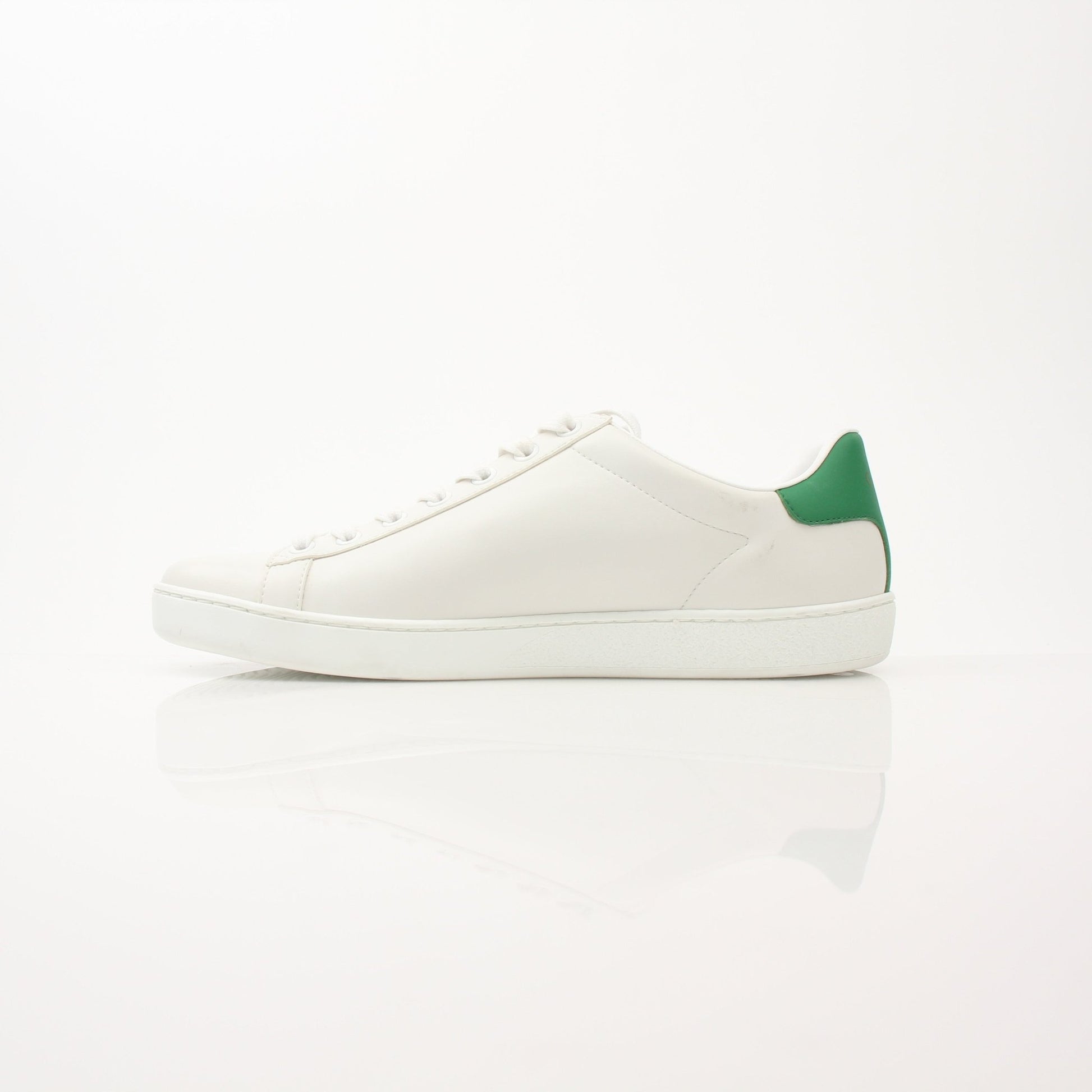 Gold & Beyond Gucci Women’s Ace Kitten Logo Sneakers showing white leather shoes with signature gold Gucci logo detail.