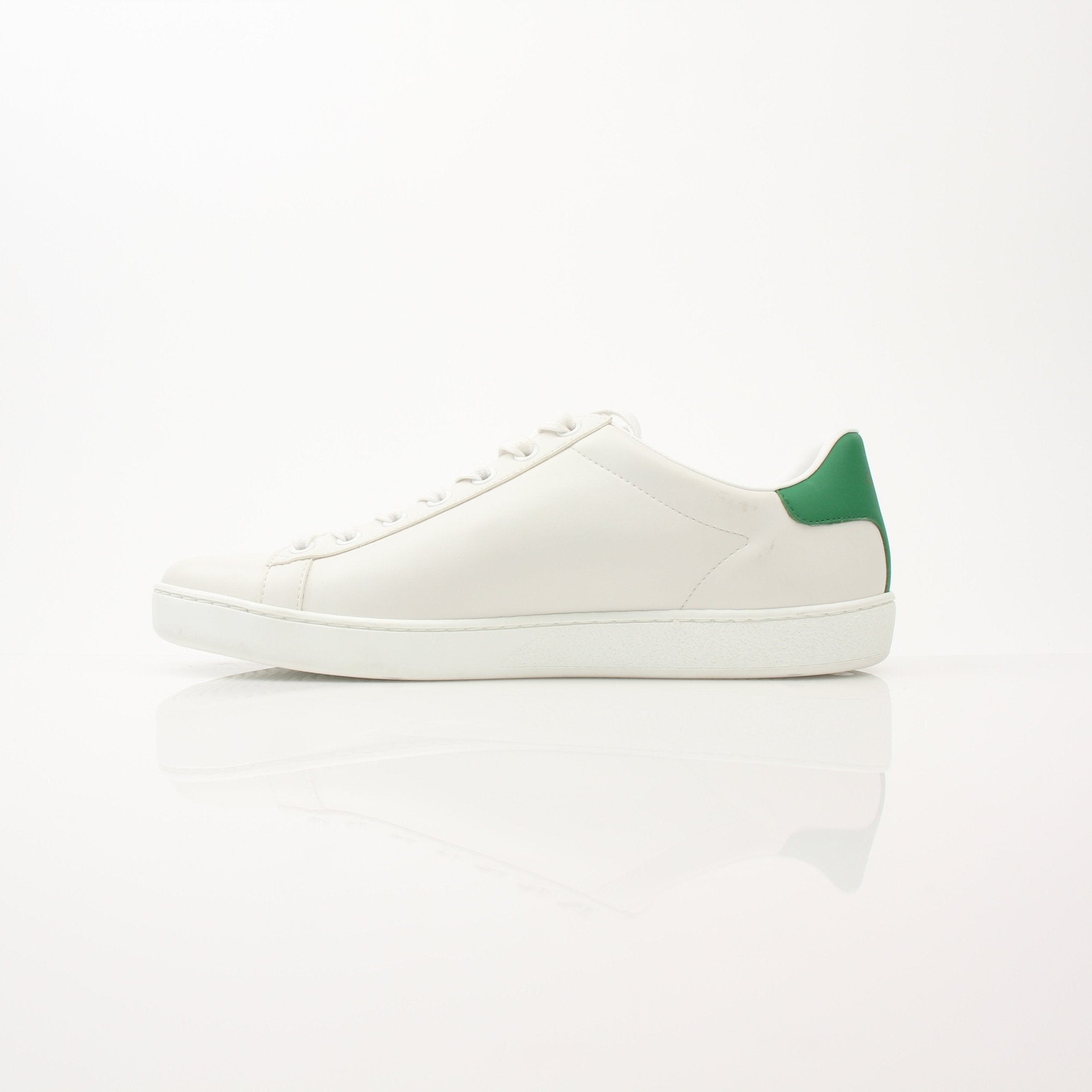 Gold & Beyond Gucci Women’s Ace Kitten Logo Sneakers showing white leather shoes with signature gold Gucci logo detail.