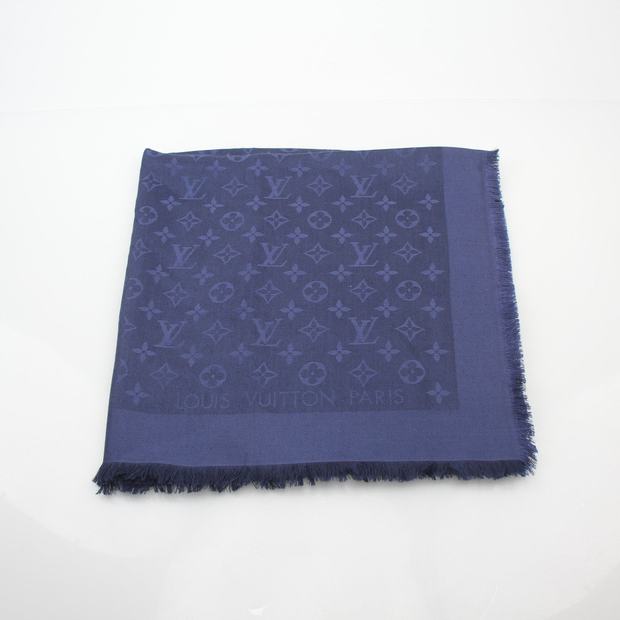 Dark blue Louis Vuitton monogram shawl with gold accents, stylish accessories for elegant fashion statements.