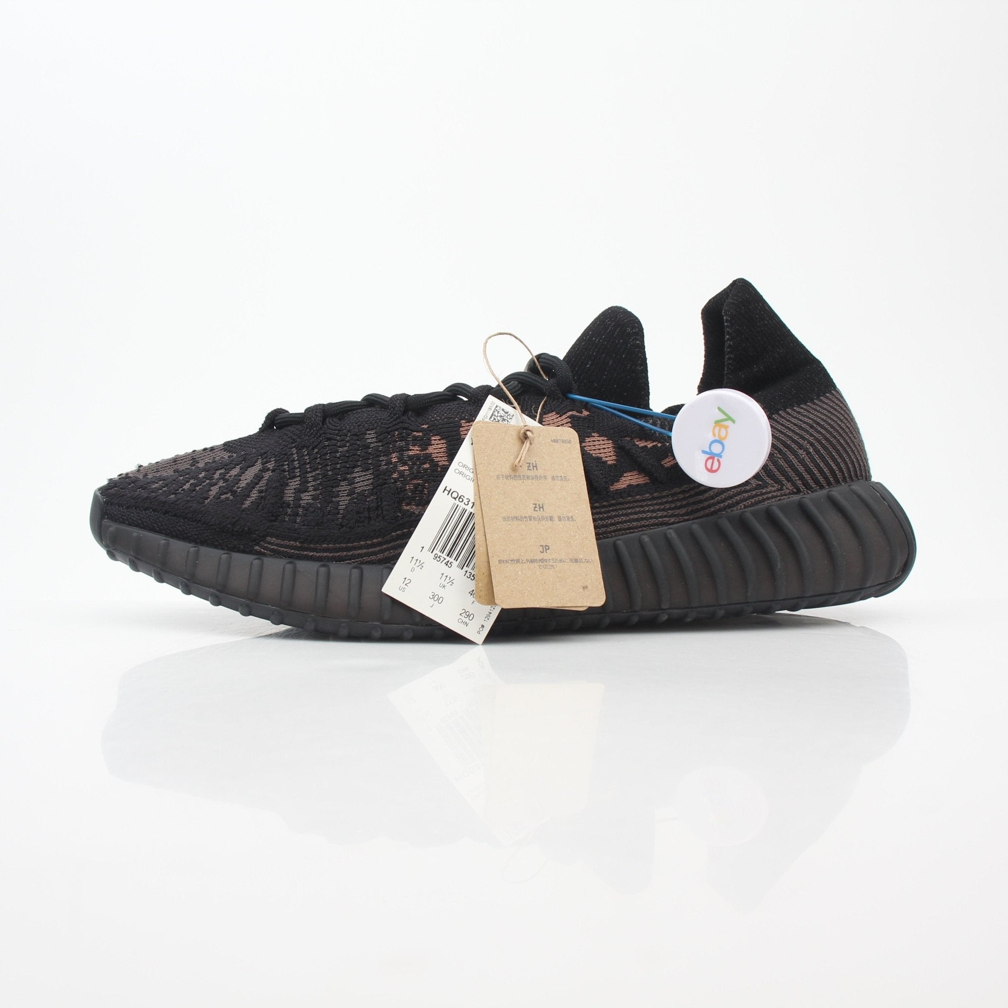 Black Adidas Yeezy Boost 350 V2 CMPCT low-top sneakers by Gold & Beyond, featuring sleek design and textured fabric.