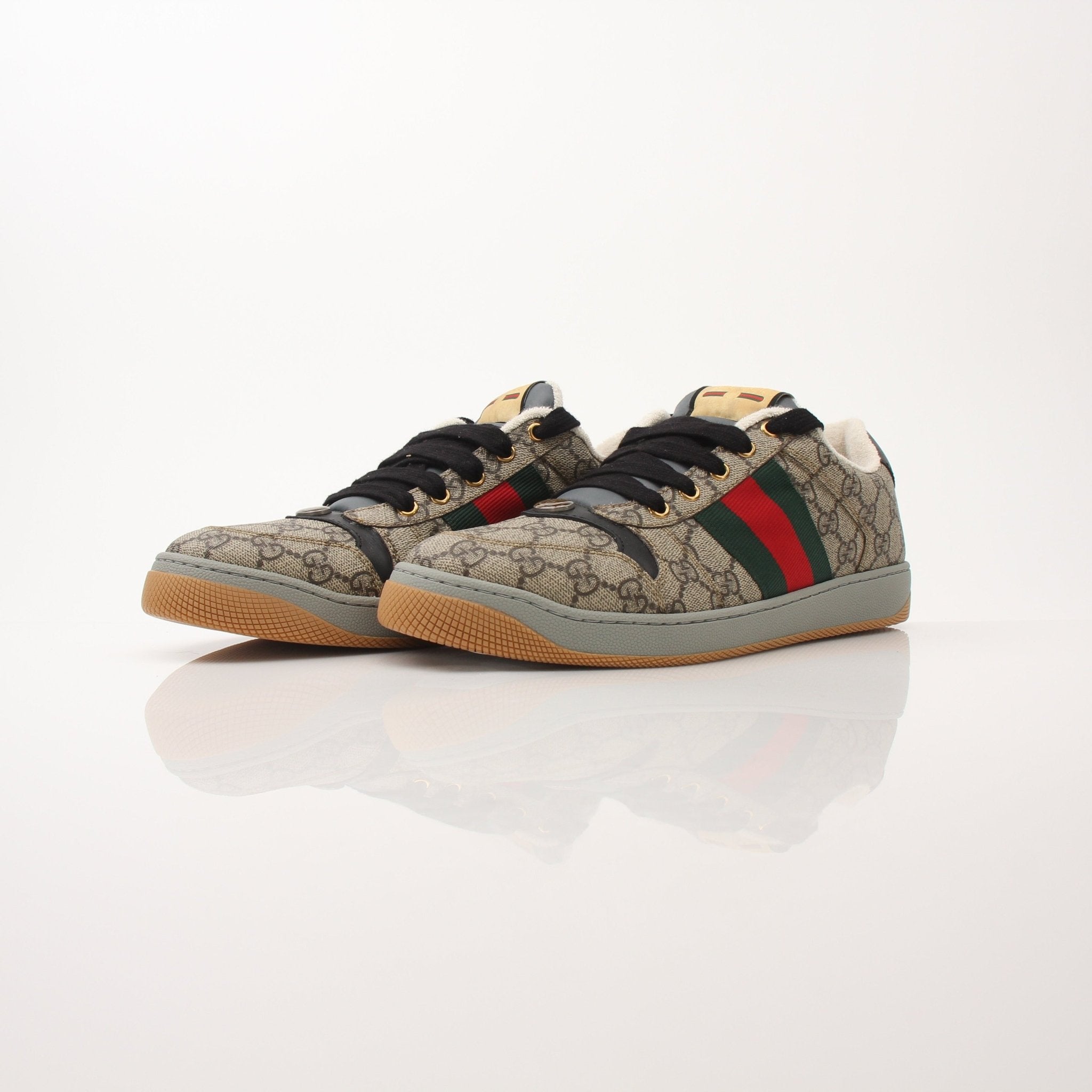 Gold & Beyond Gucci Men’s Screener GG sneakers, stylish black shoes with signature logo details, on a clean white background.