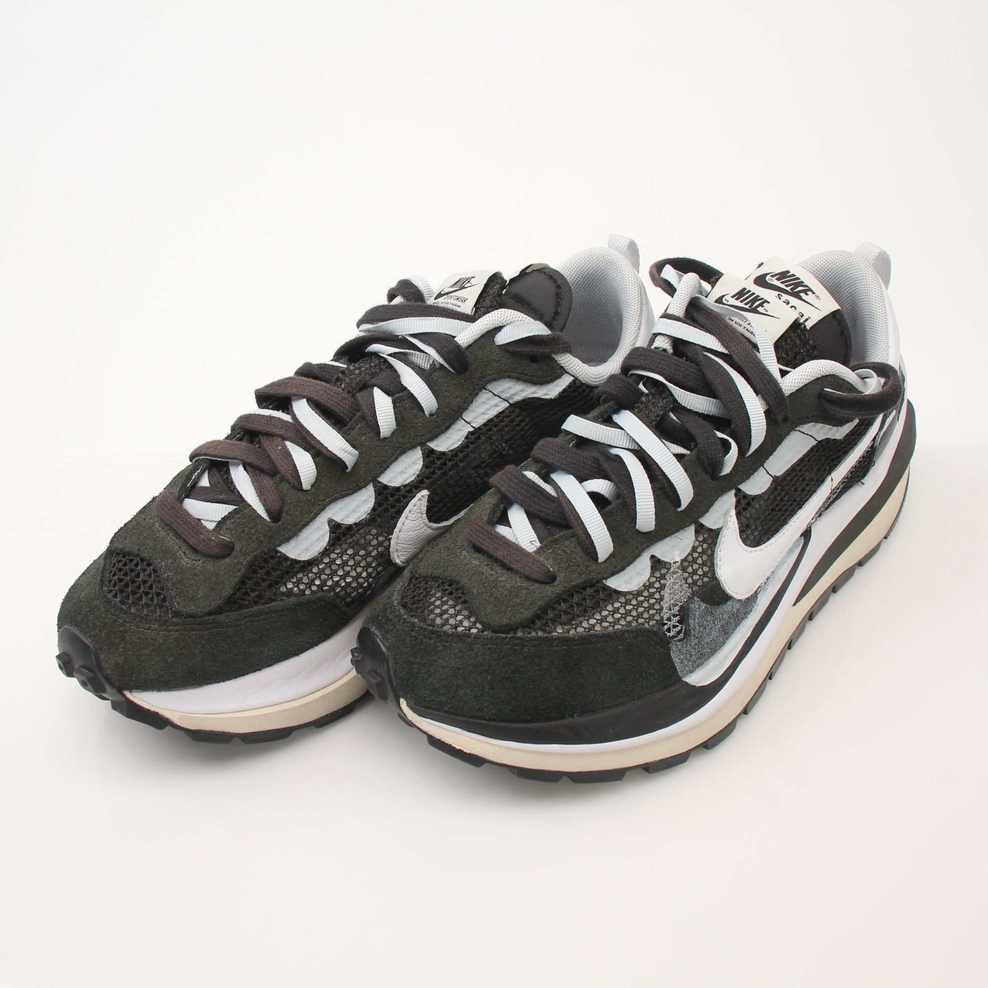 Nike x Sacai VaporWaffle sneakers for men, athletic shoes with layered design and mixed materials, shown in a close-up image.