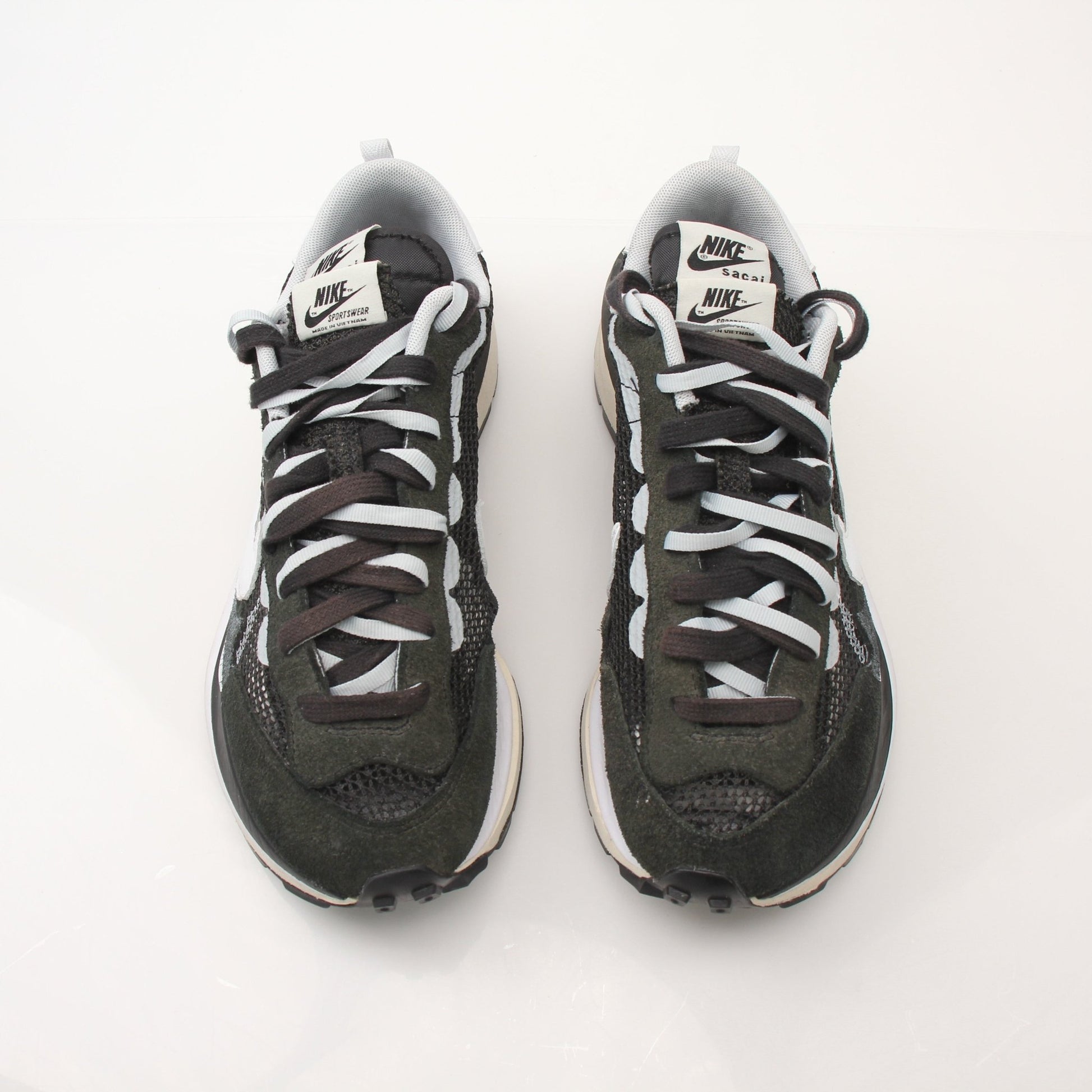 Nike x Sacai VaporWaffle men's sneakers in black and white with layered design and chunky sole, displayed on a plain background.