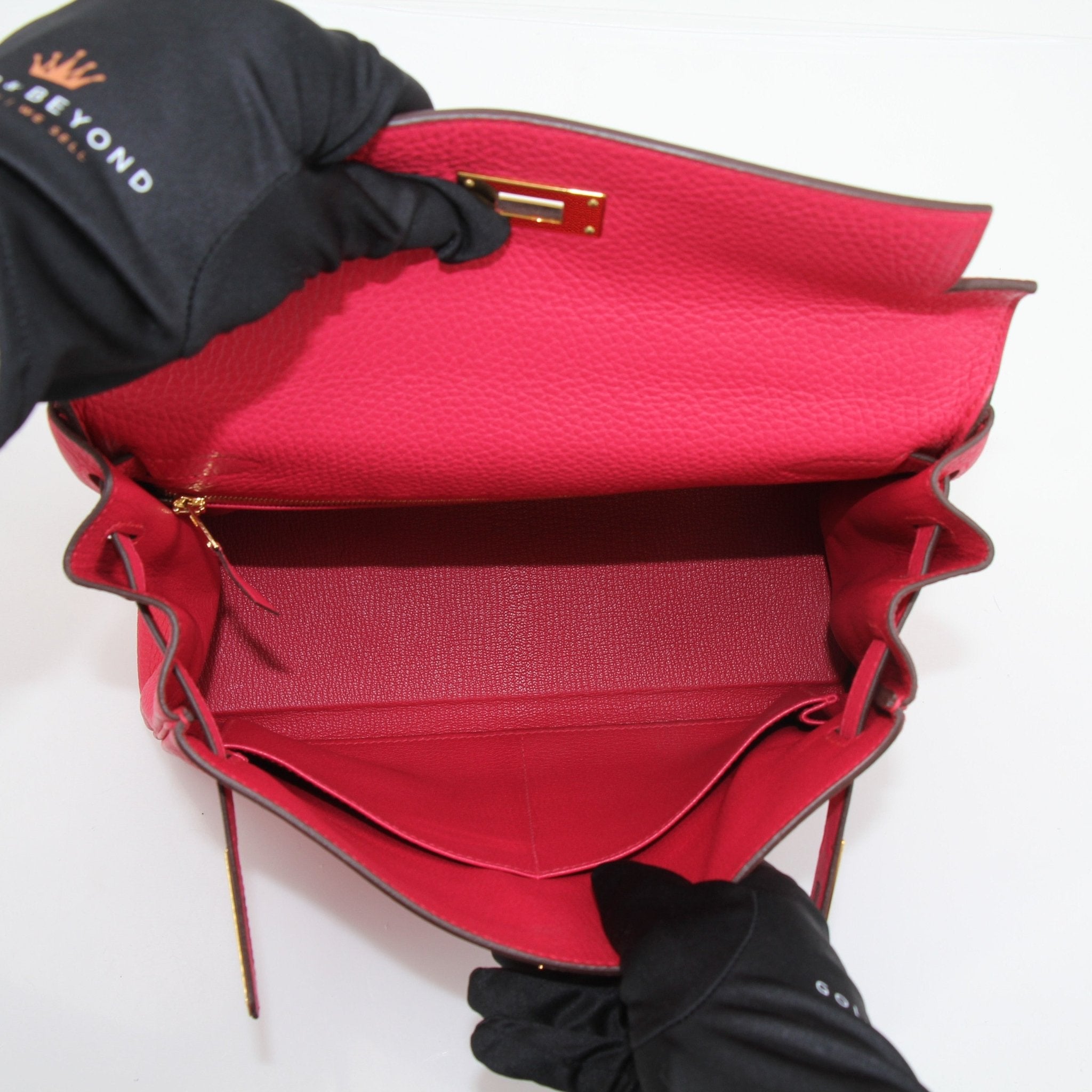 Hermès Kelly 28 Pink Togo handbag with gold hardware, featuring a structured design and top handle, displayed on a neutral background.