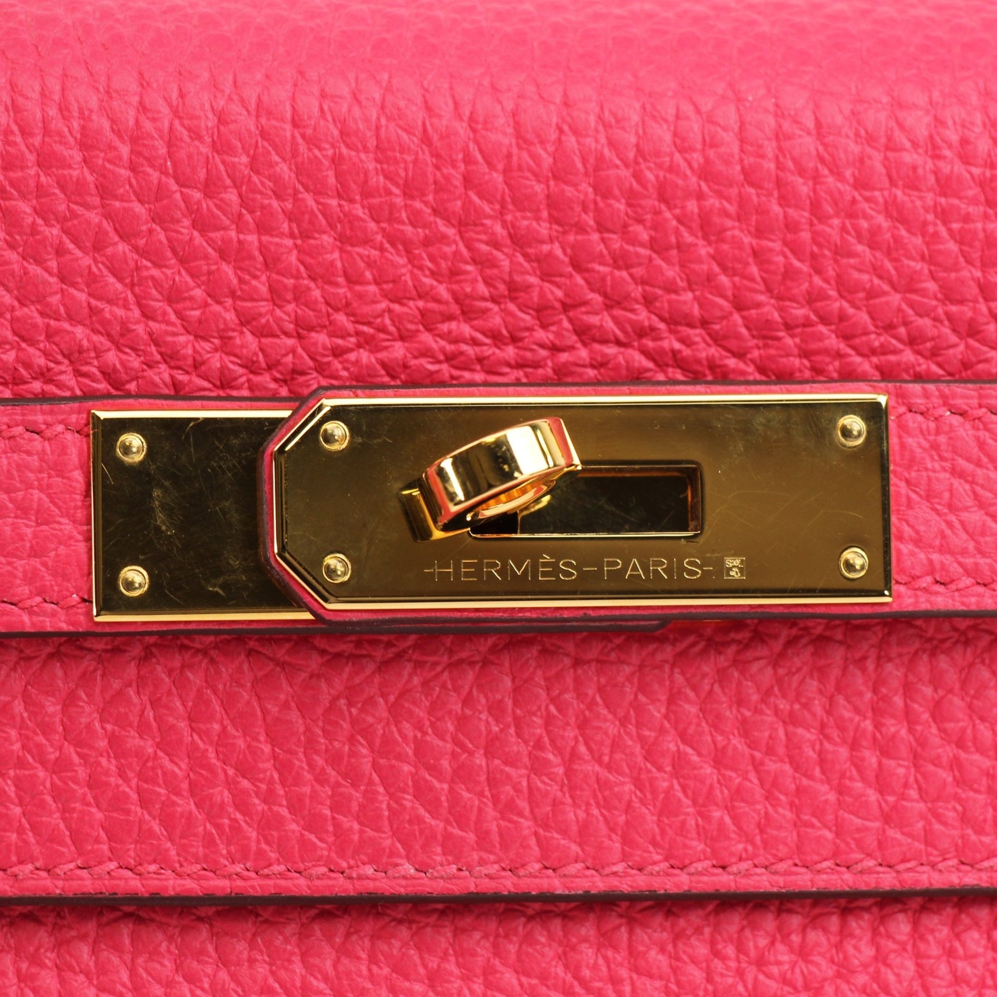 Hermès Kelly 28 pink Togo leather handbag with gold hardware, featuring structured design and top handle.