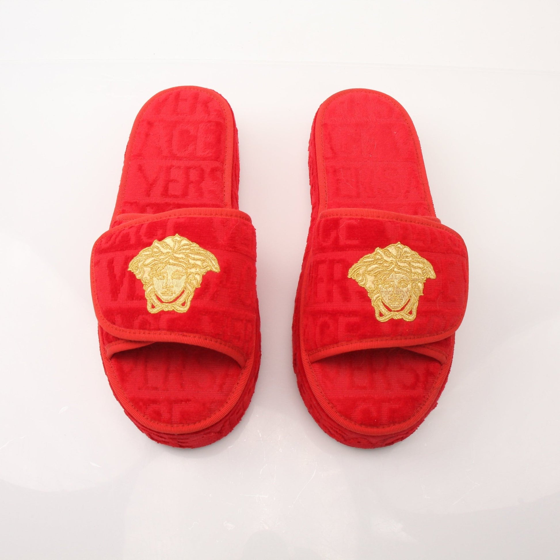Red Versace women's slippers with all-over gold accents and stylish slip-on design from Gold & Beyond.