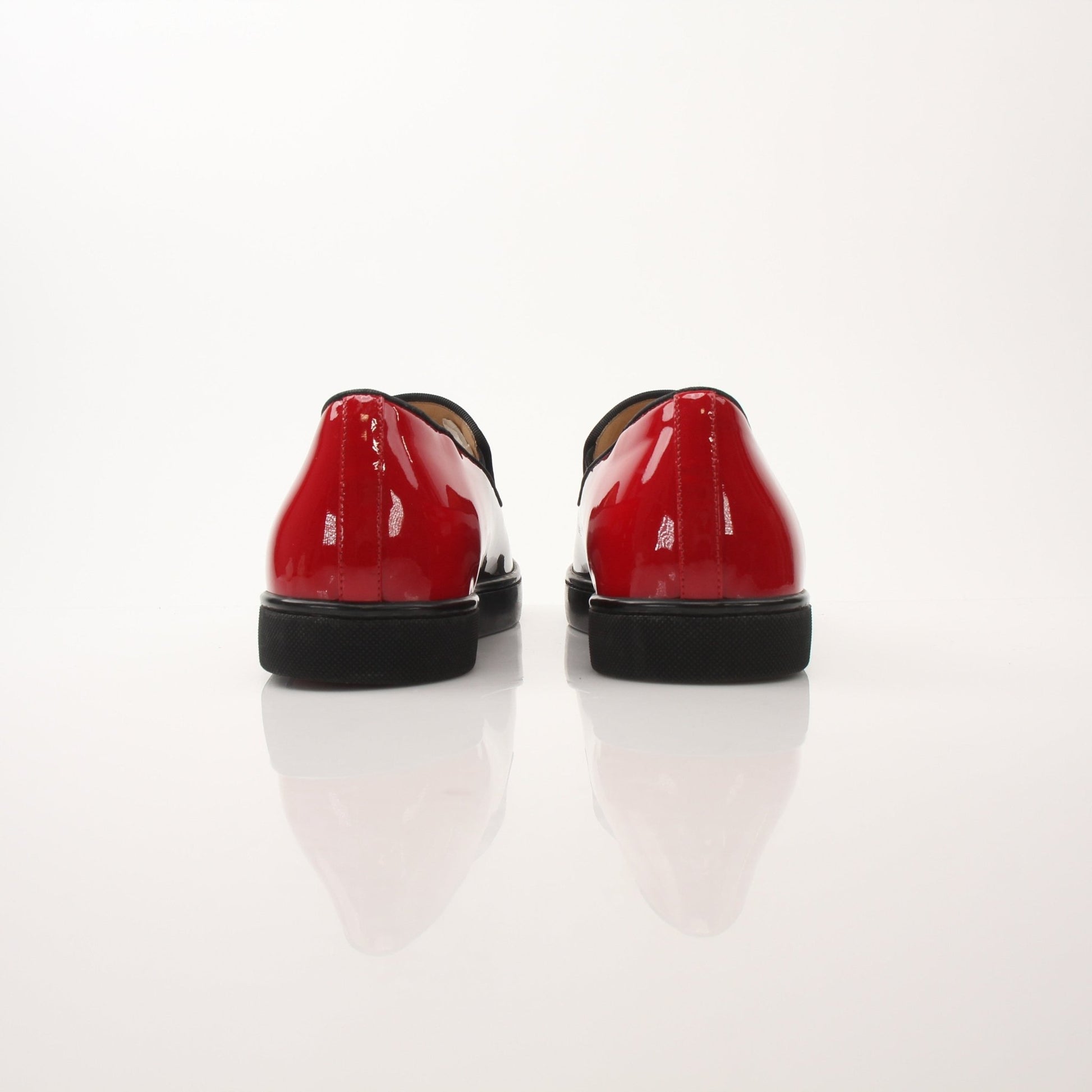Christian Louboutin men's Pin Boat slip-on sneakers in navy blue with red soles, casual shoe style, brand logo visible.