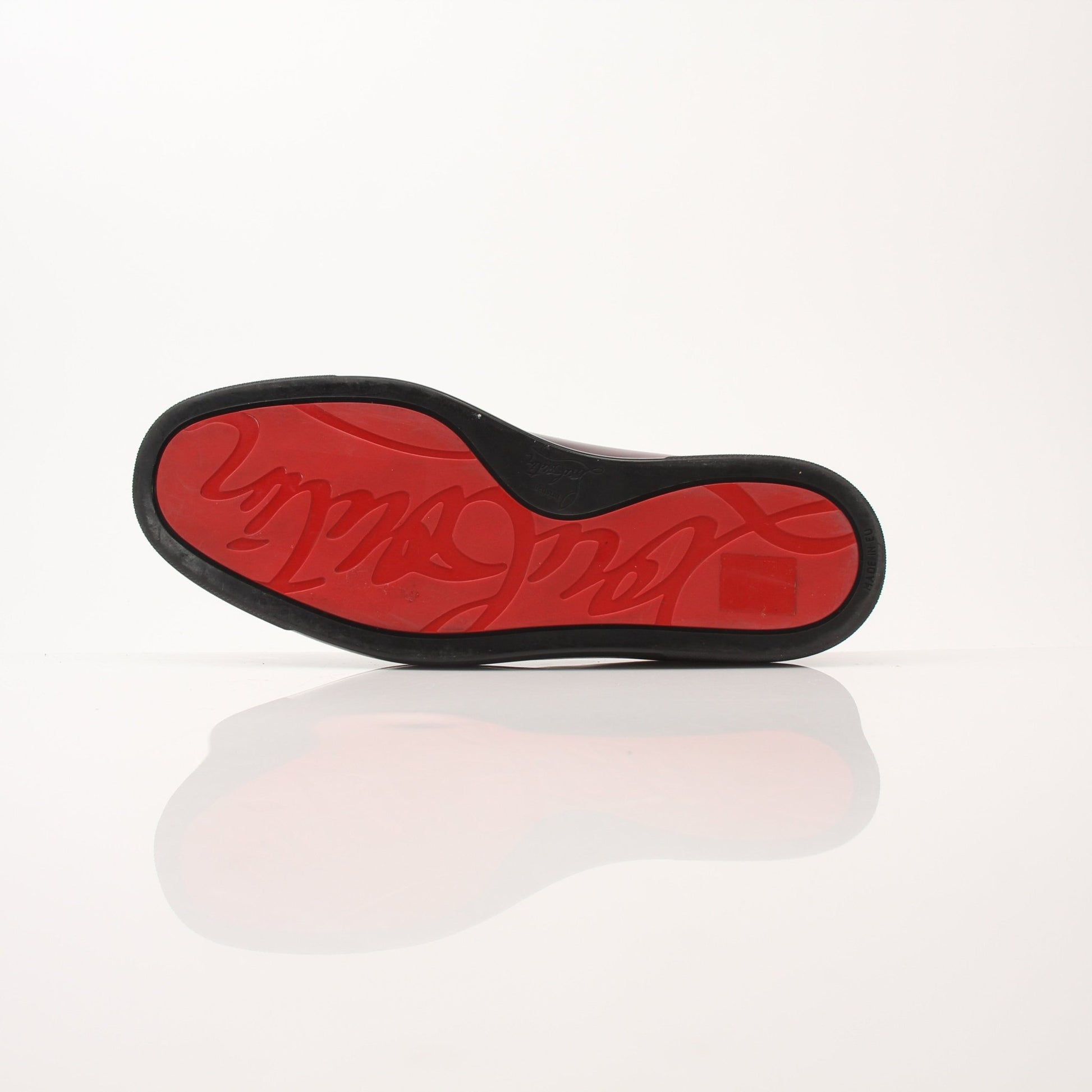 Christian Louboutin men's Pin Boat slip-on sneakers with black leather and signature red sole, stylish and comfortable shoes by Gold & Beyond.