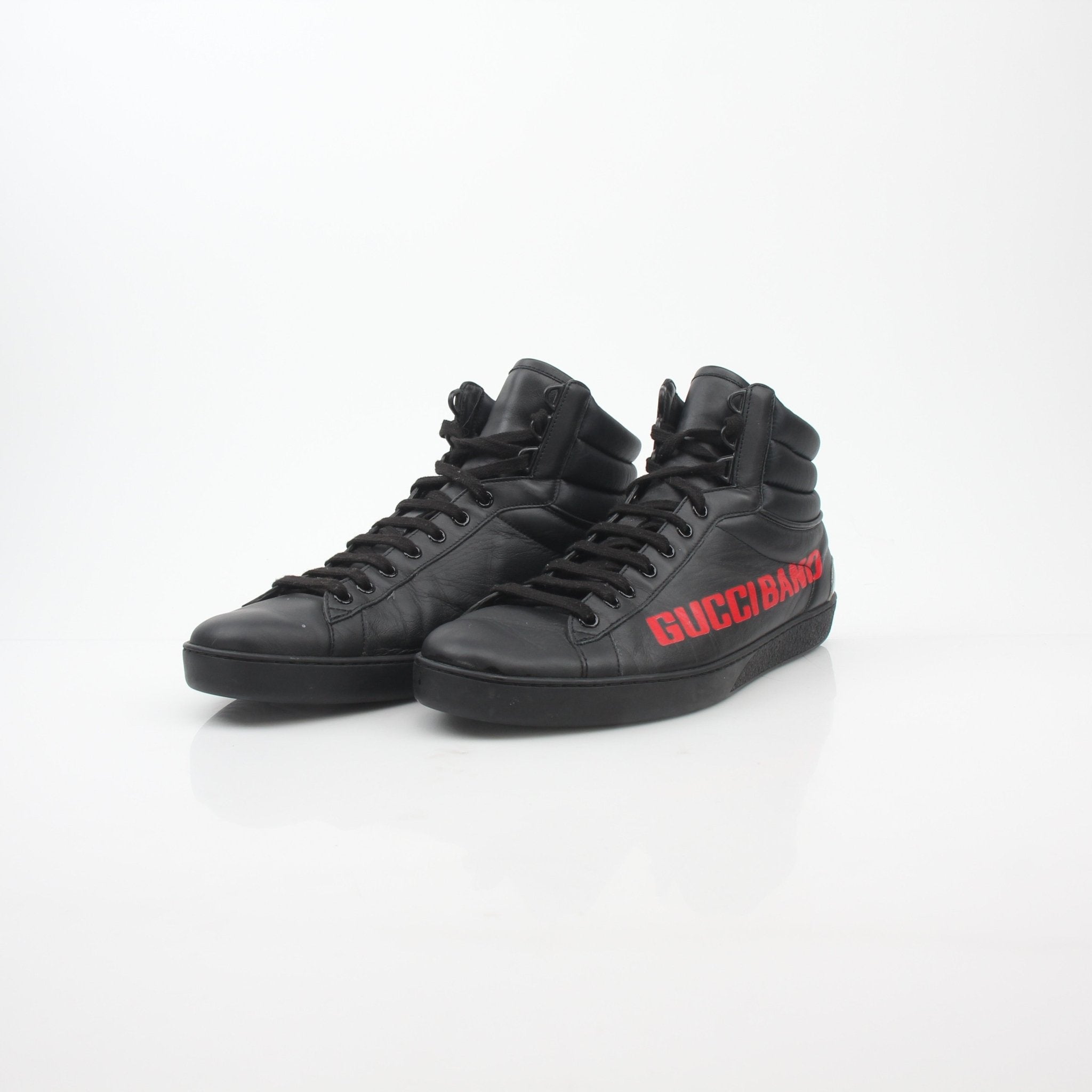 Black Gucci Ace “Gucci Band” high-top sneakers with white sole and signature logo, displayed on a neutral background.