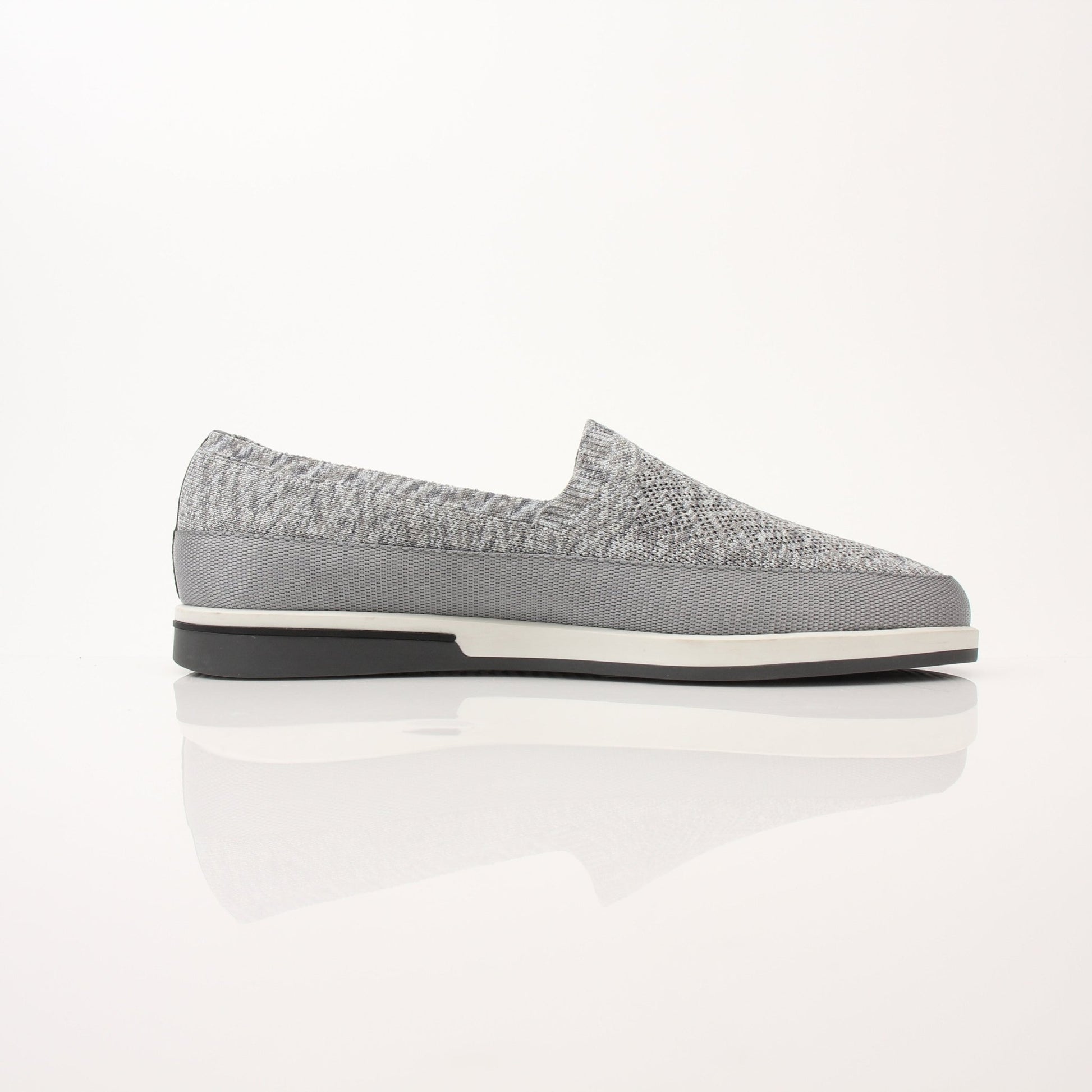 Gold & Beyond Prada Men’s Saint Tropez slip-on sneakers with white soles and sleek design, displayed on a neutral background.