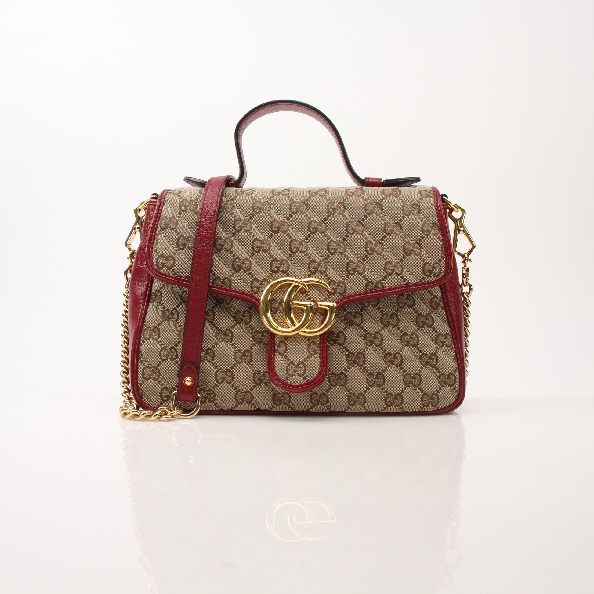 Gold & Beyond Gucci GG Marmont top handle handbag with quilted leather and gold hardware, stylish and elegant accessory.