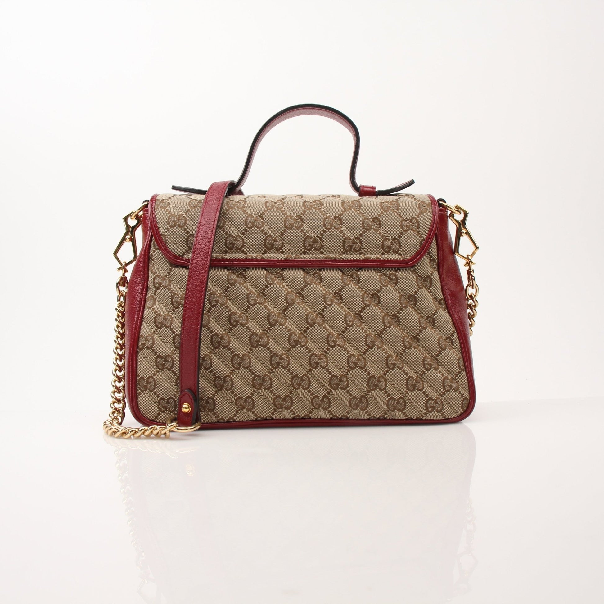 Gucci GG Marmont top handle handbag in black leather with gold hardware, featuring chevron quilting and a chain strap.