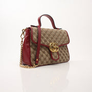 Gold & Beyond Gucci GG Marmont top handle handbag with quilted leather and gold hardware, stylish and elegant for everyday use.