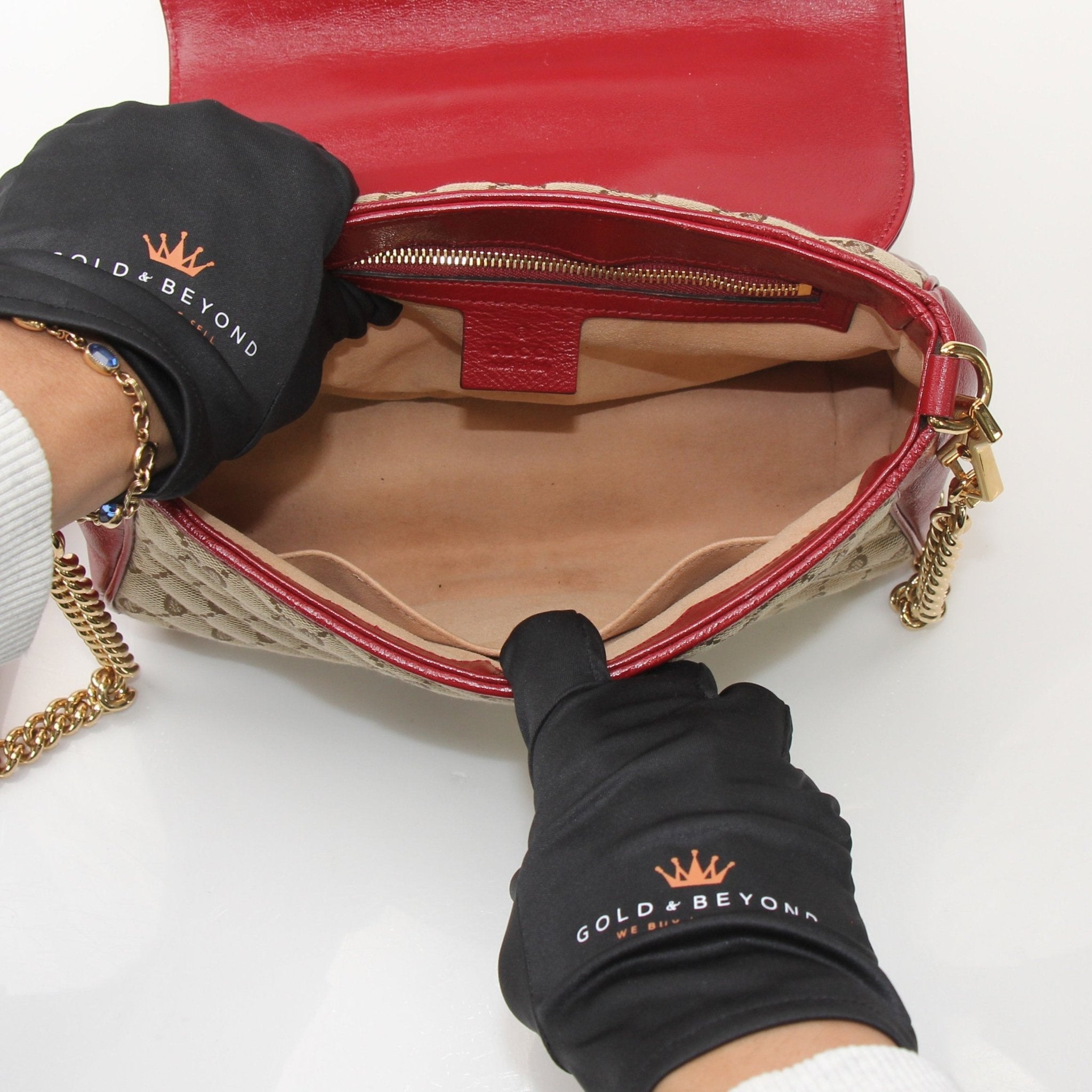 Gold & Beyond Gucci GG Marmont top handle handbag with quilted leather, gold hardware, and signature logo details.