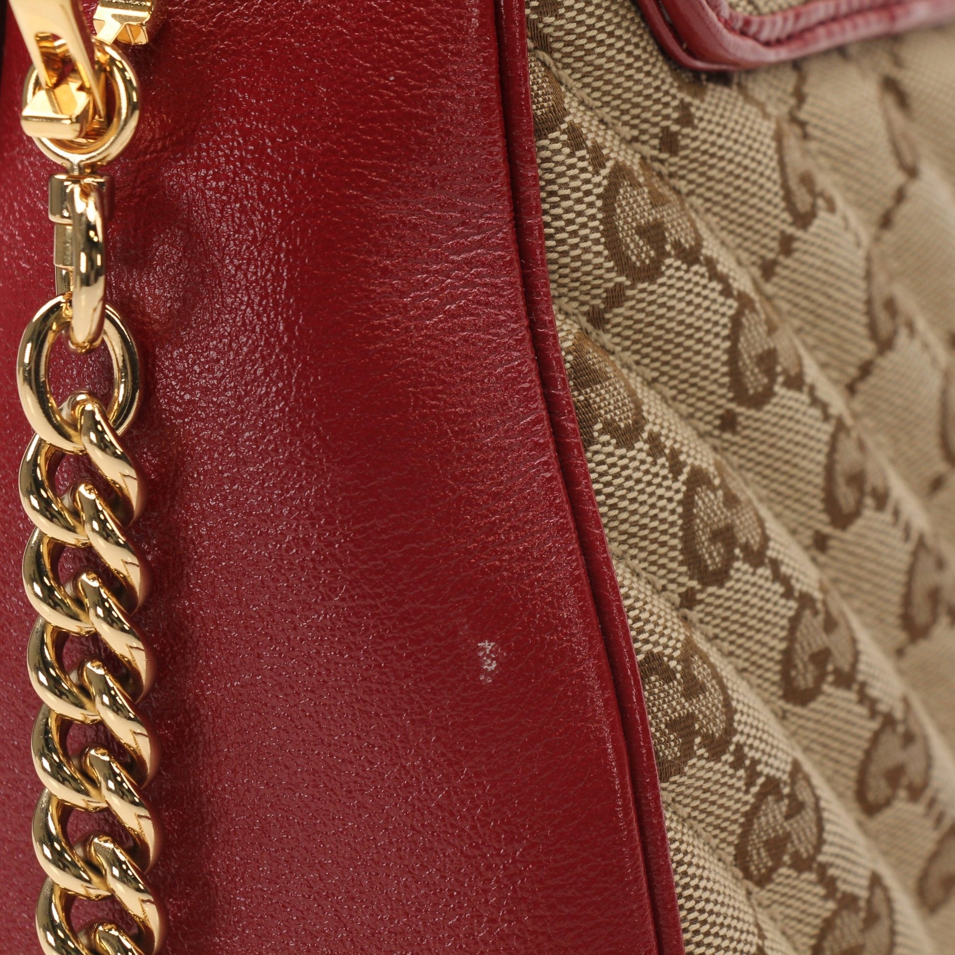 Gold & Beyond Gucci GG Marmont top handle handbag with quilted leather and gold-tone hardware, featuring a structured design.