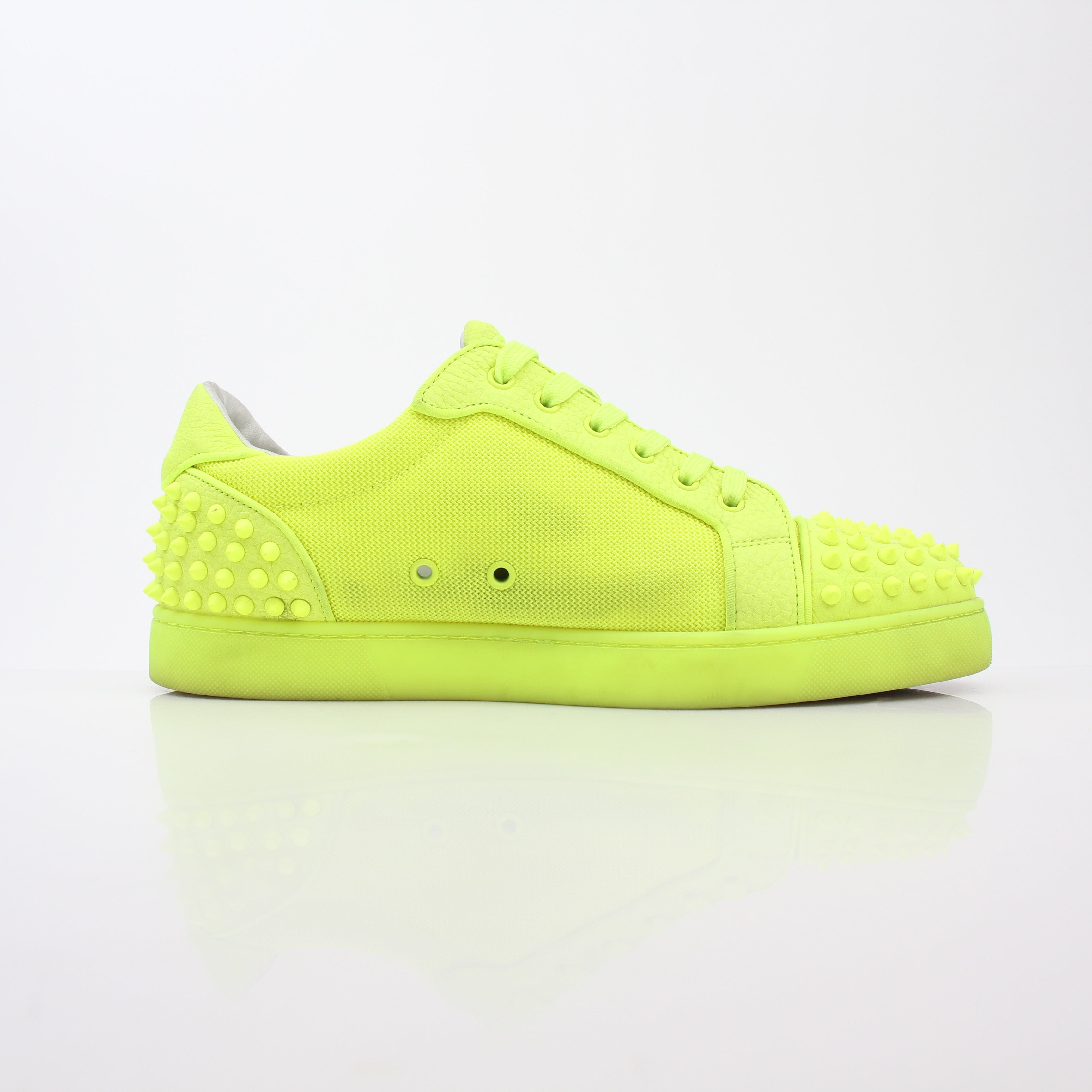 Christian Louboutin Neon Yellow Seavaste 2 Orlato sneakers with black accents and signature red soles, displayed on a white background.