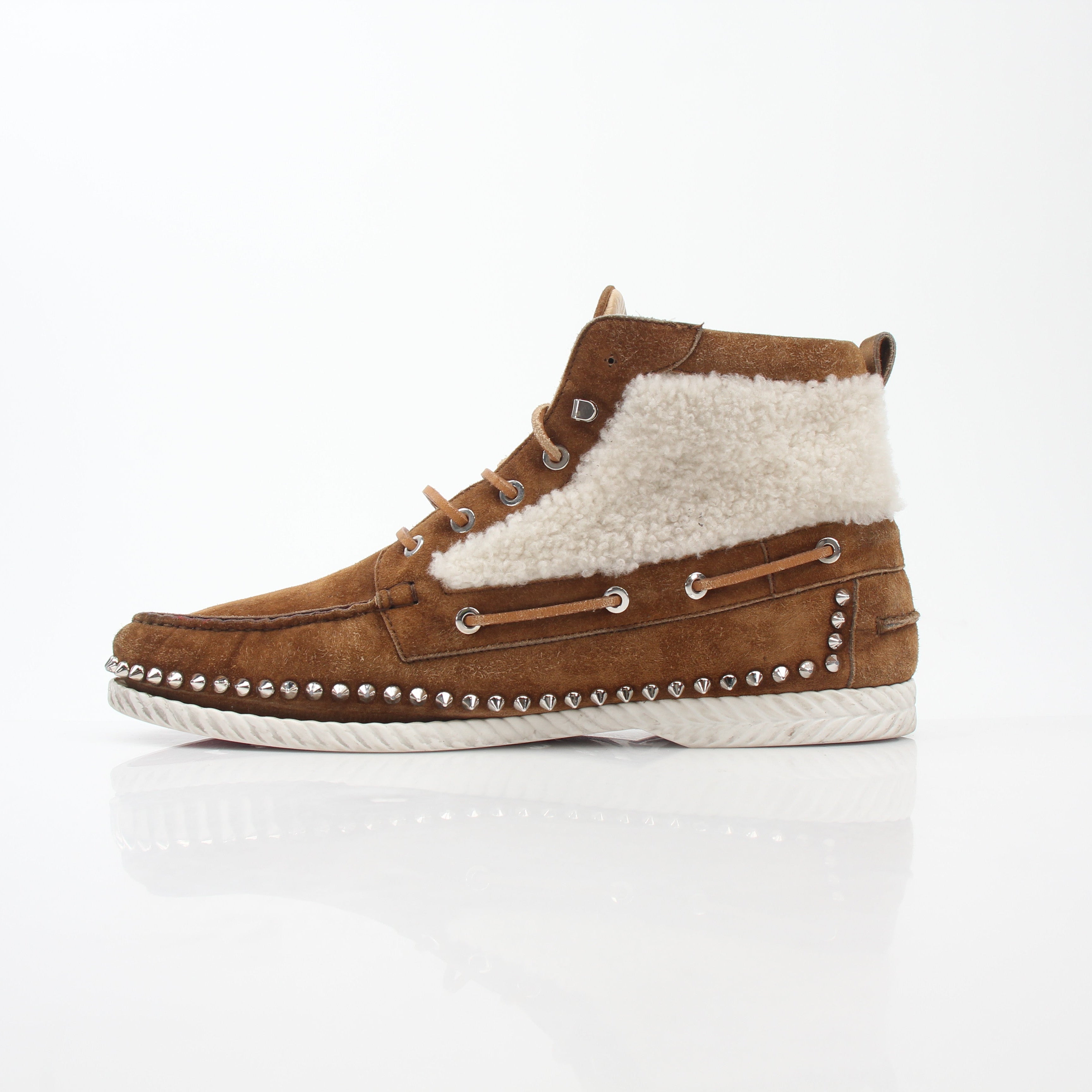 Christian Louboutin shearling flat boots with ankle-high design and luxurious shearling lining, shown in a stylish footwear image.