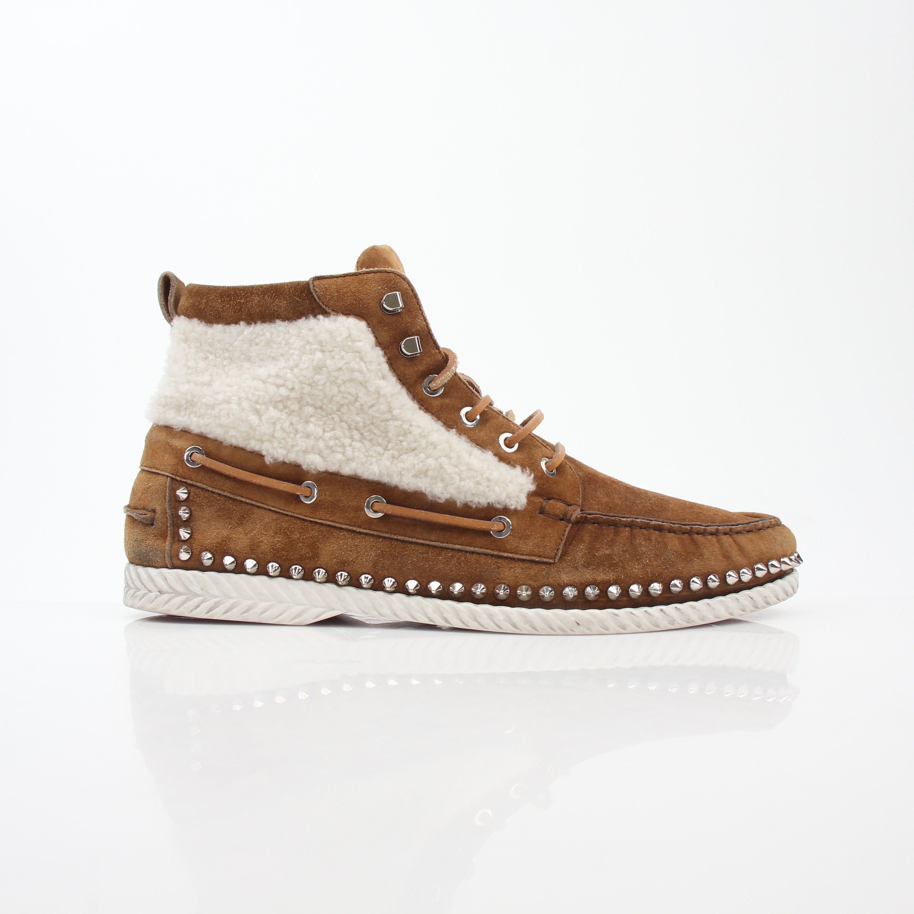 Christian Louboutin shearling flat boots featuring black leather, red sole, and ankle-high design with shearling trim.