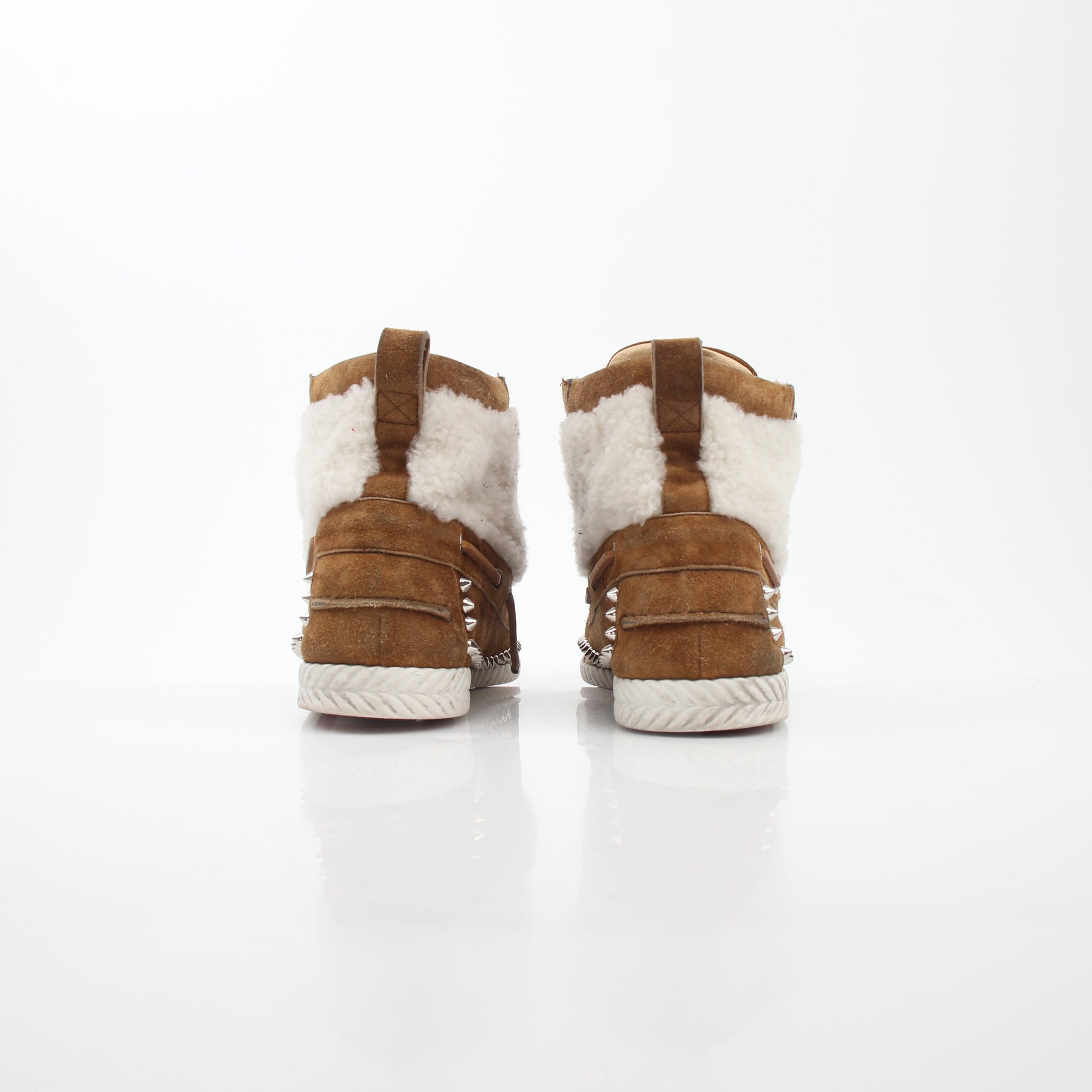Christian Louboutin shearling flat boots featuring ankle-high design and luxurious shearling lining, styled with elegant details.