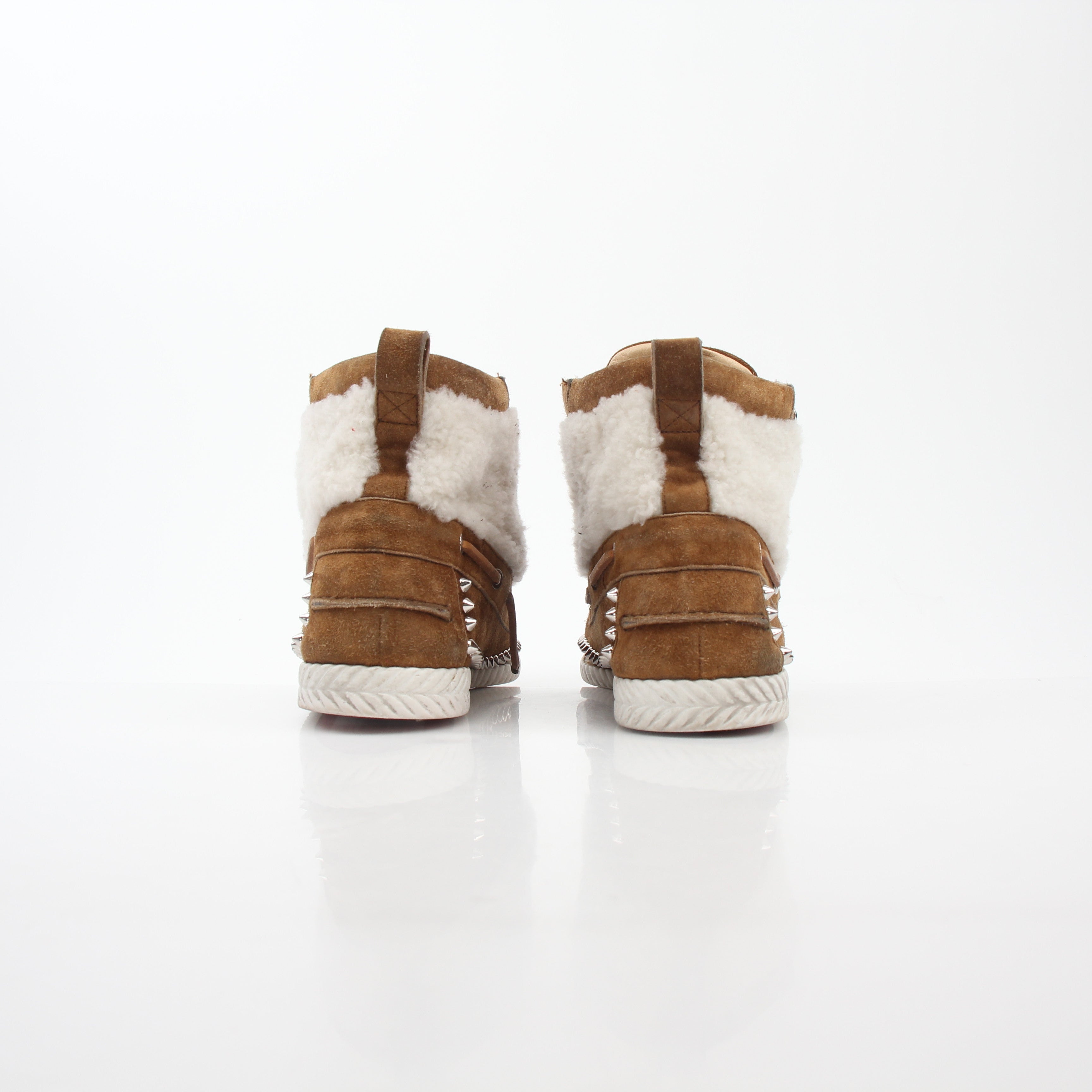 Christian Louboutin shearling flat boots featuring ankle-high design and luxurious shearling lining, styled with elegant details.