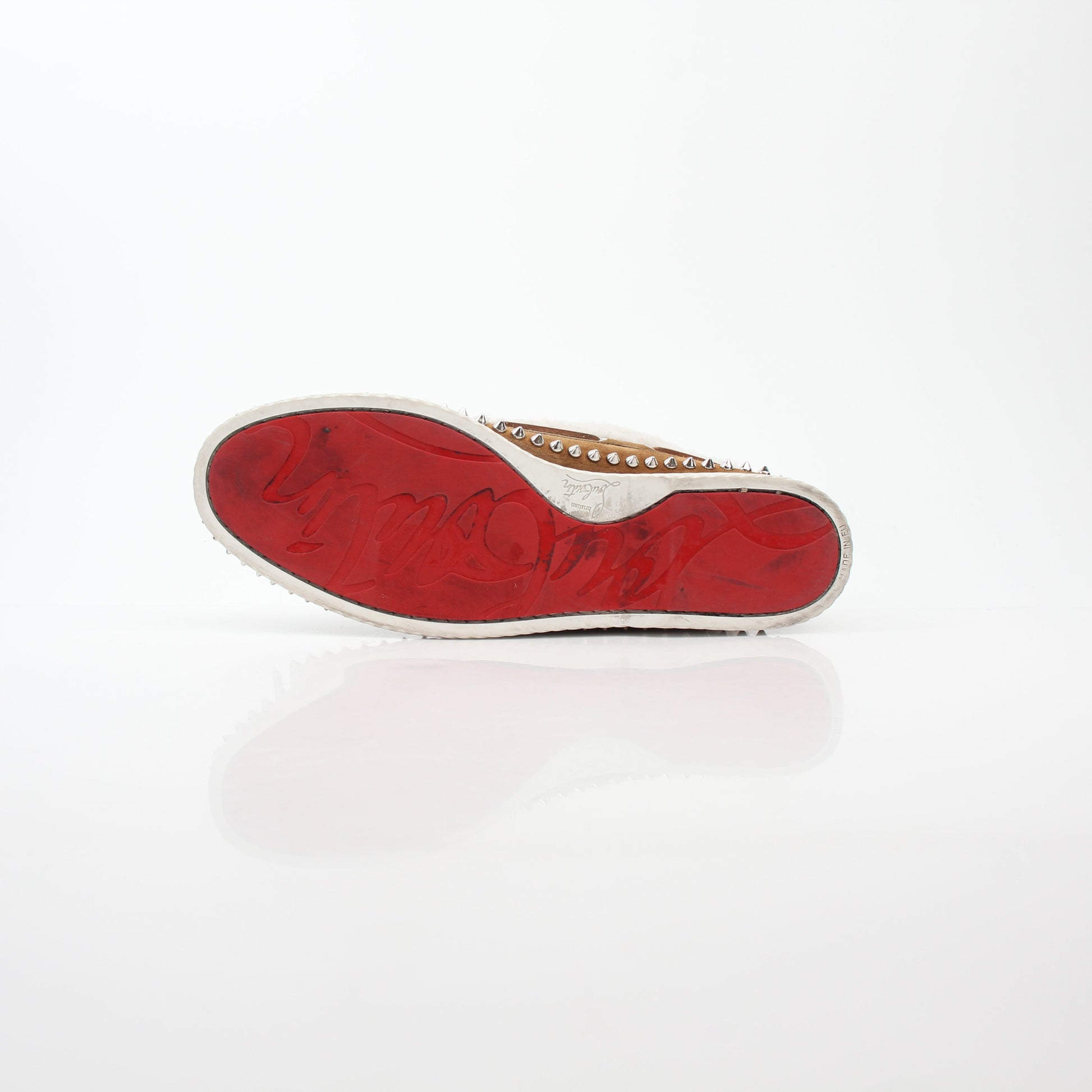 Christian Louboutin shearling flat ankle boots with red soles, black leather exterior, and gold accents, displayed on a white background.