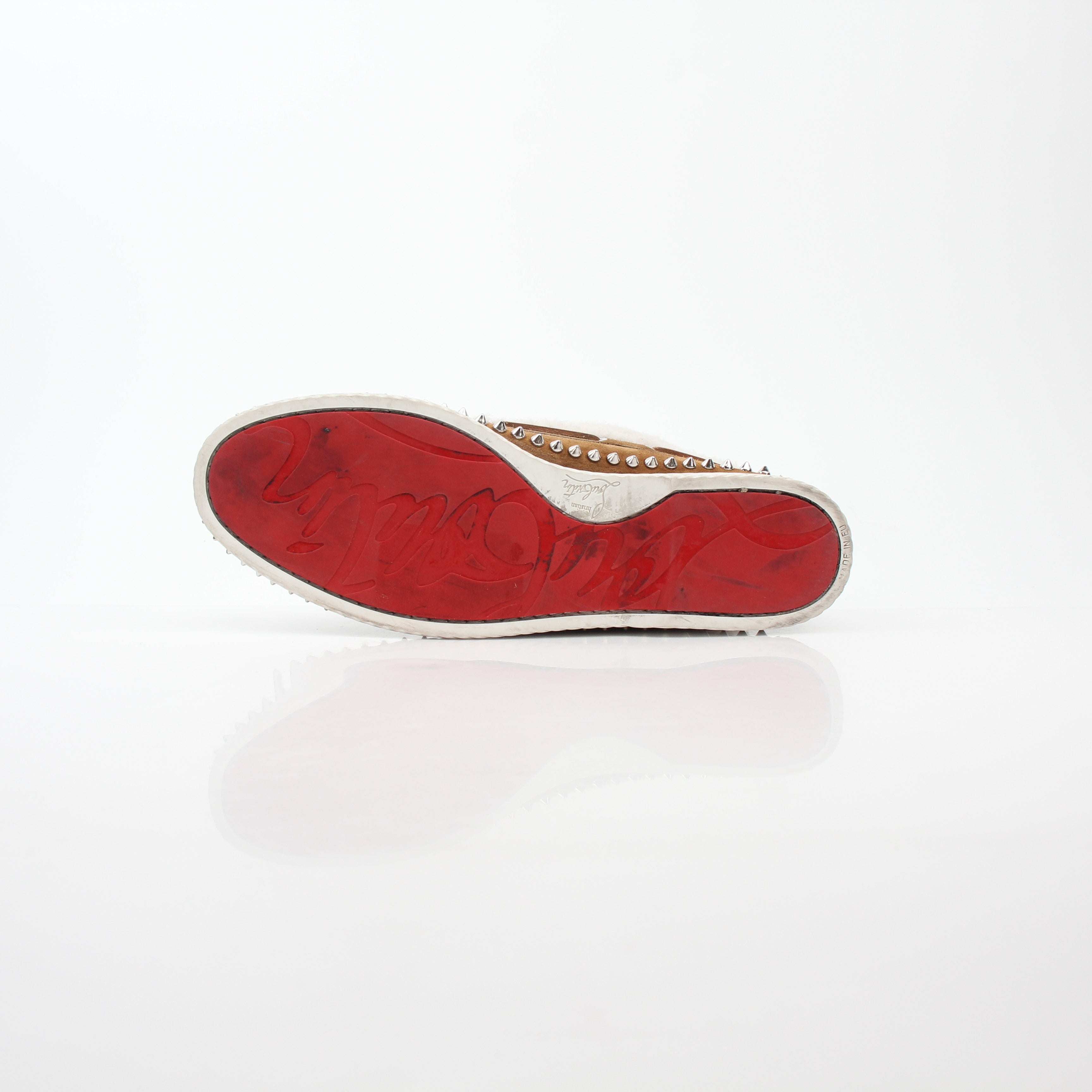 Christian Louboutin shearling flat ankle boots with red soles, black leather exterior, and gold accents, displayed on a white background.