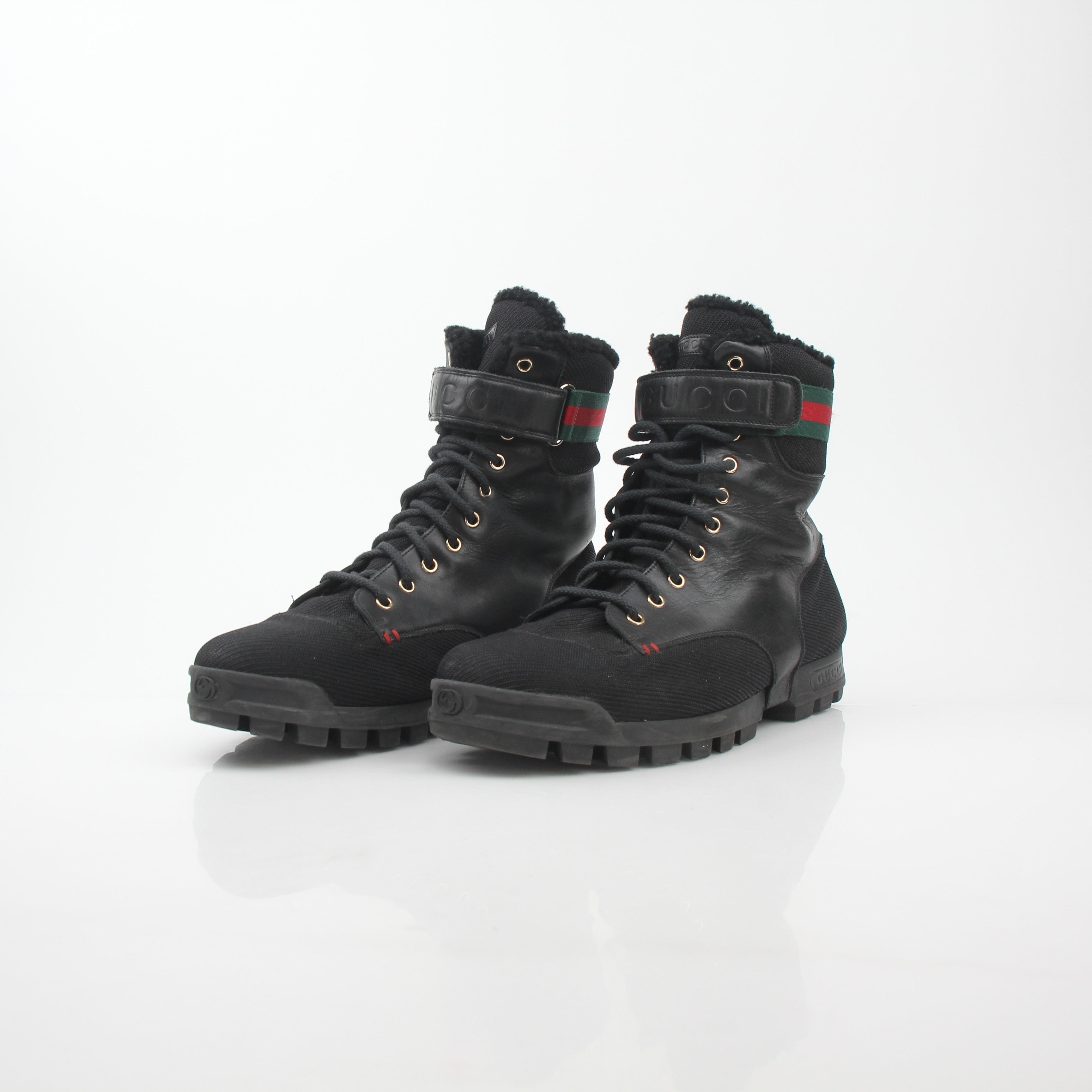 Gucci black Web accent combat boots with rugged sole and lace-up design, featuring signature branding and stylish detailing.
