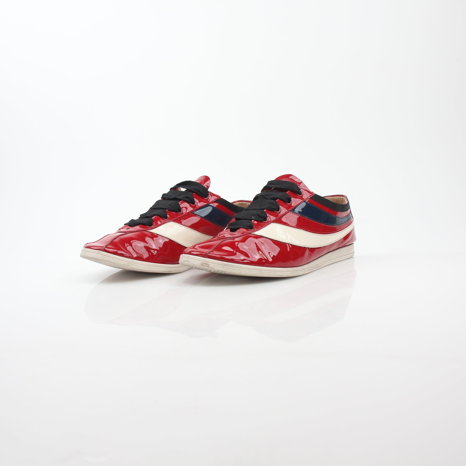 Gucci Red Falacer Hebron Web sneakers with gold accents, featuring a sporty shoe design and distinctive web detailing.