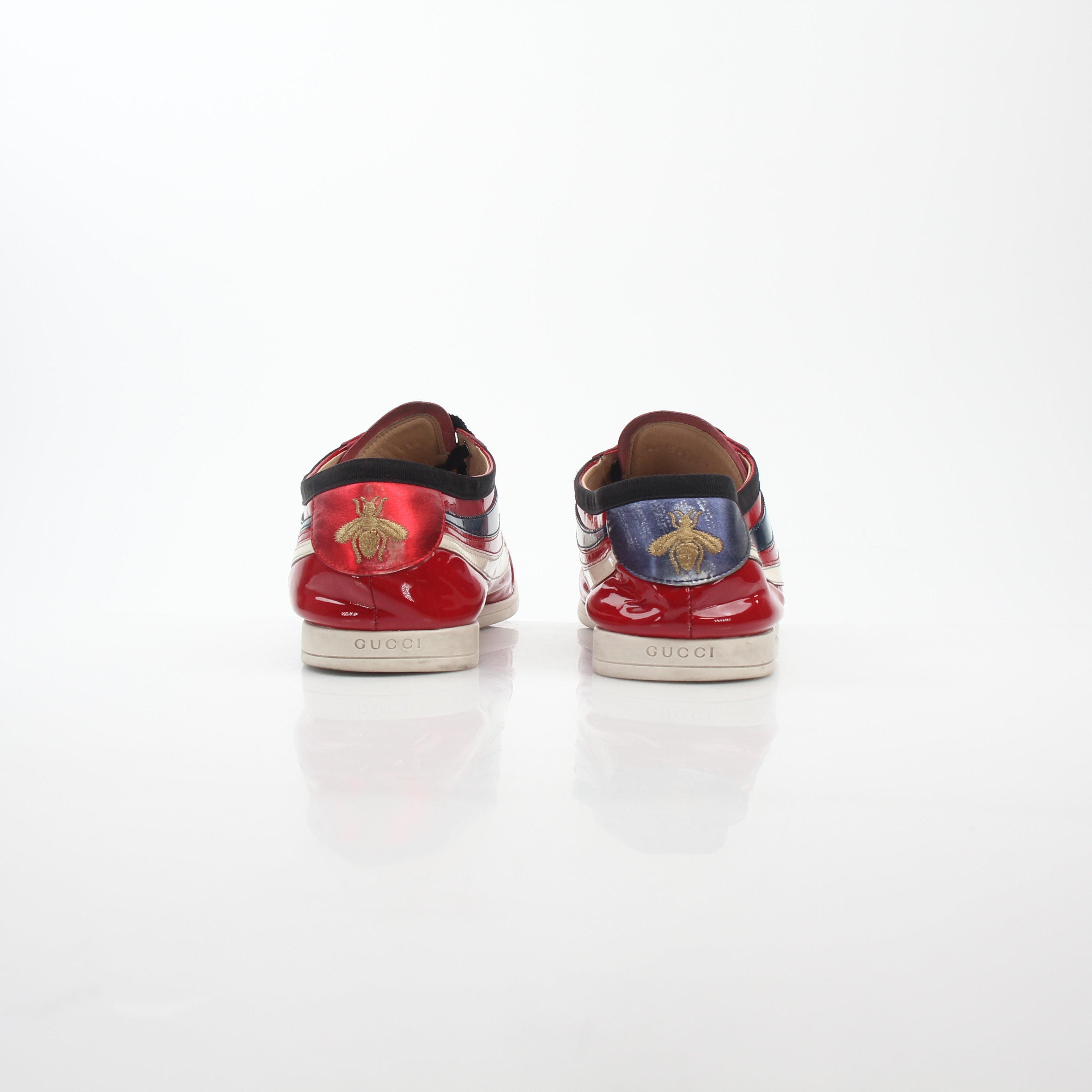 Gucci Red Falacer Hebron Web sneakers in shoes, featuring red fabric and web detailing, displayed on a white background.