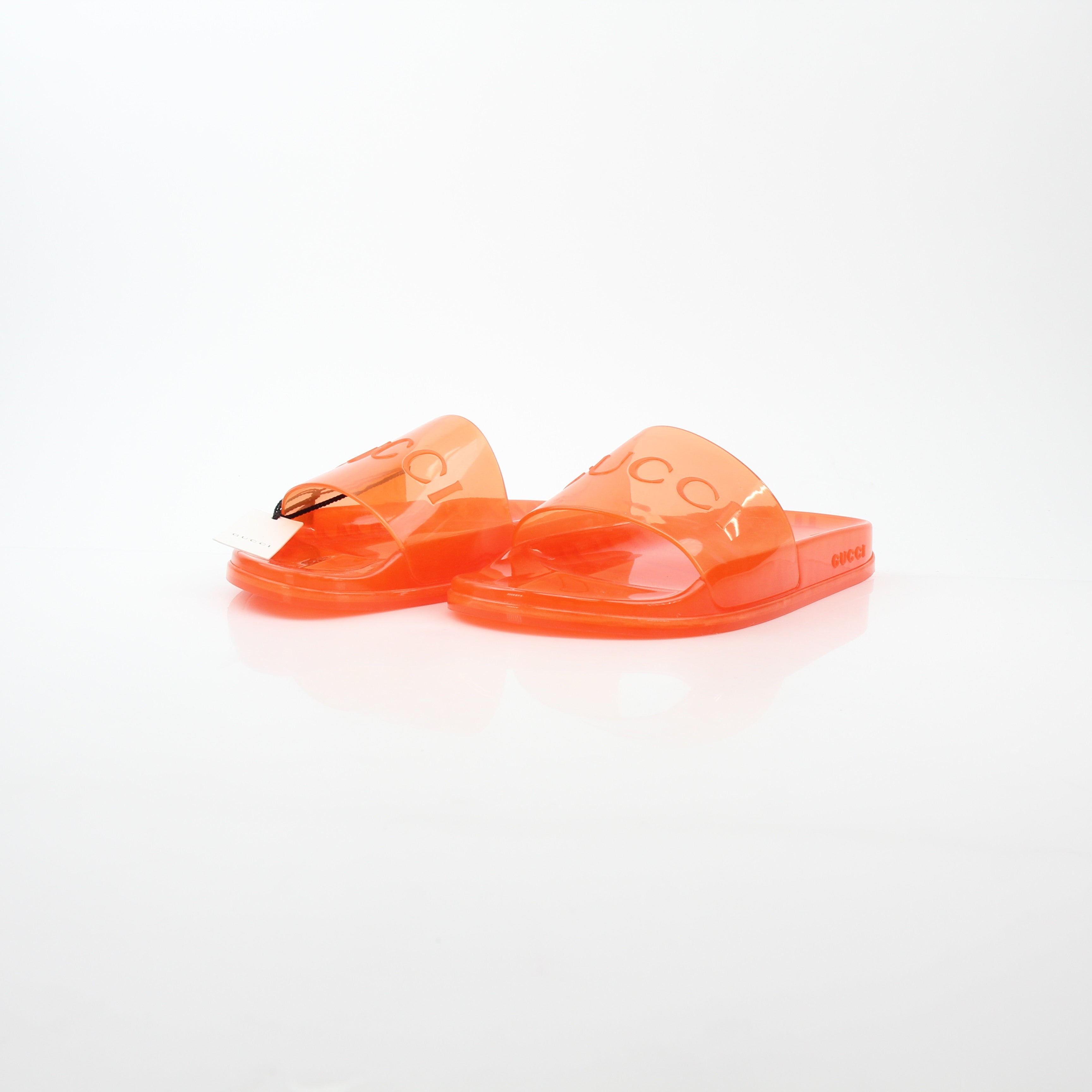Gucci orange Pursuit logo slide sandals with open toe design and branded strap, displayed on a white background.
