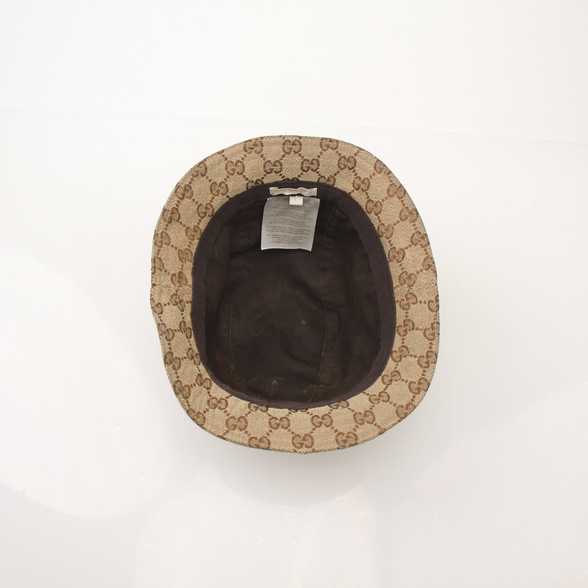 Gucci GG canvas bucket hat in beige and brown with adjustable chin strap, stylish accessories for sun protection and fashion.