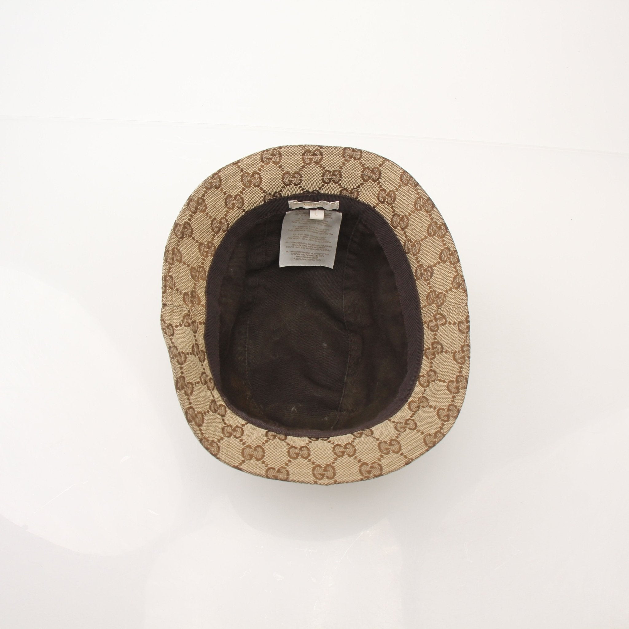 Gucci GG canvas bucket hat in beige and brown with adjustable chin strap, stylish accessories for sun protection and fashion.