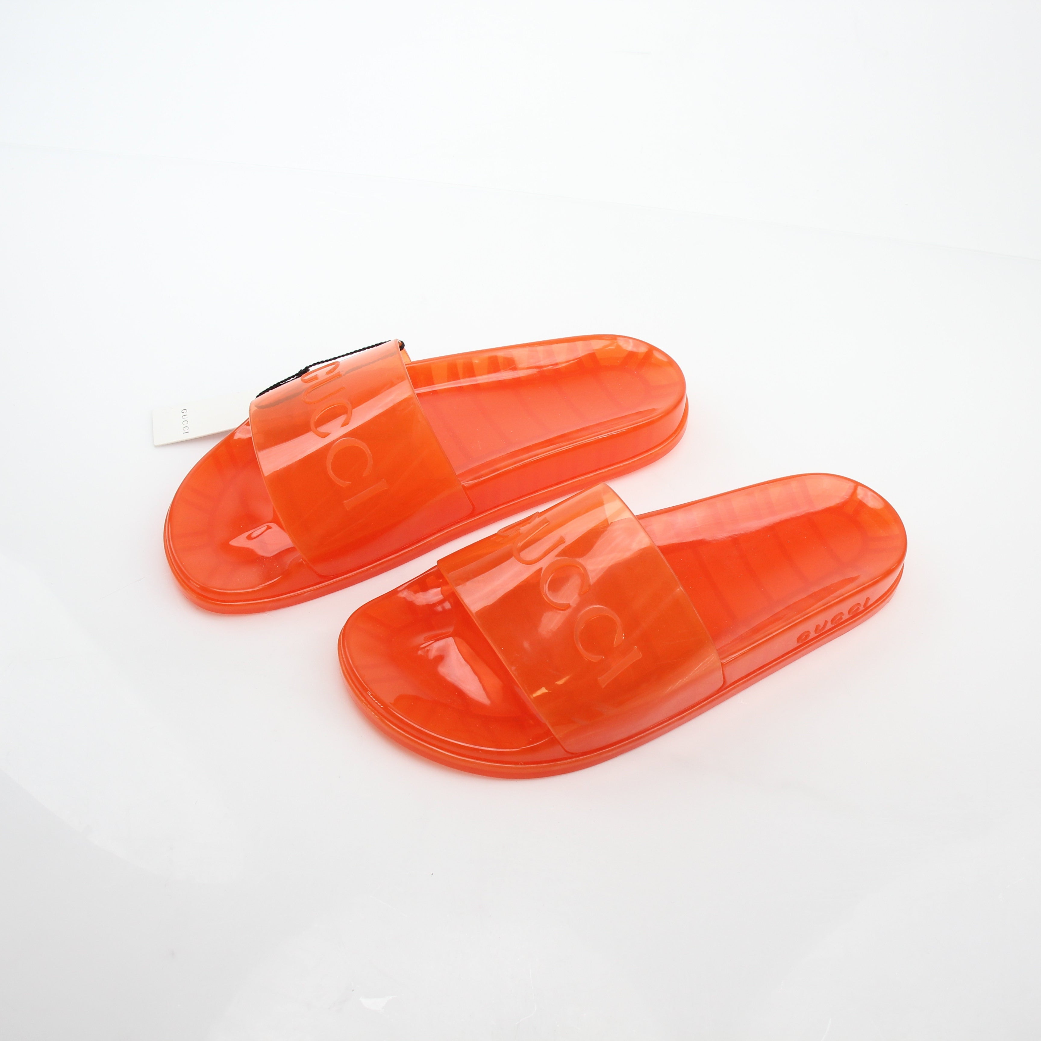 Gucci orange Pursuit logo slide sandals with open toe and strap, featuring Gucci branding on the stylish slip-on shoes.