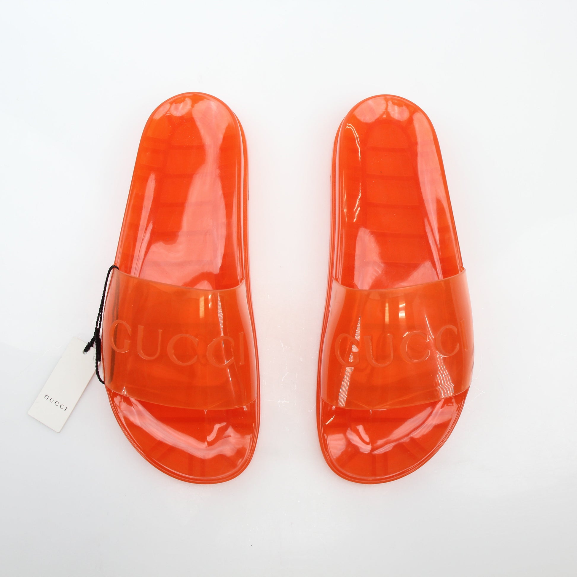 Gucci orange Pursuit logo slide sandals on gold and beyond shoes, featuring branded strap and comfortable design