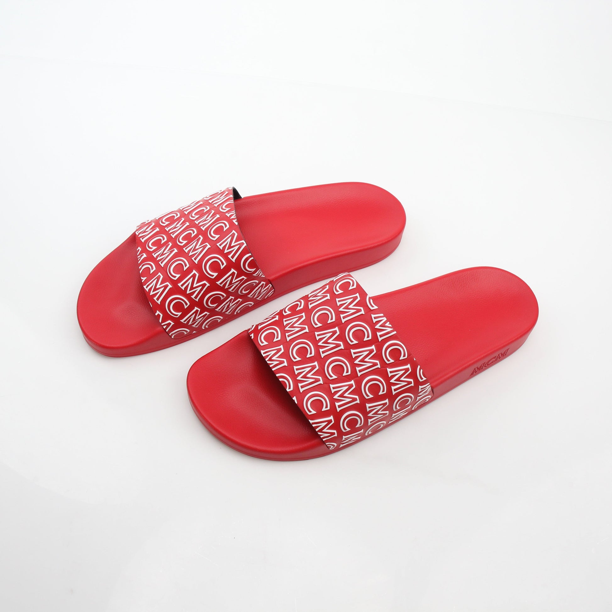 Red MCM logo print slide sandals by Gold & Beyond, featuring comfortable open-toe design and branded straps.