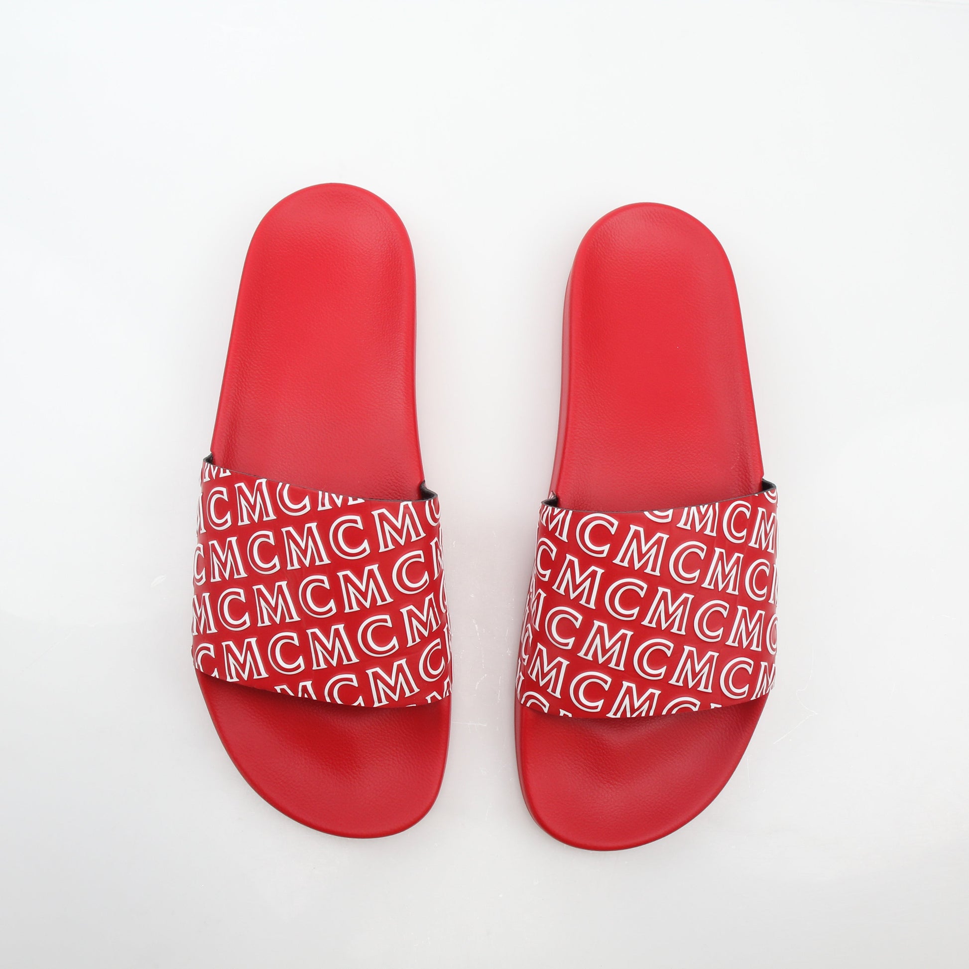 Gold & Beyond MCM red logo print slide sandals with open toe and wide straps, showcasing the brand's signature design.
