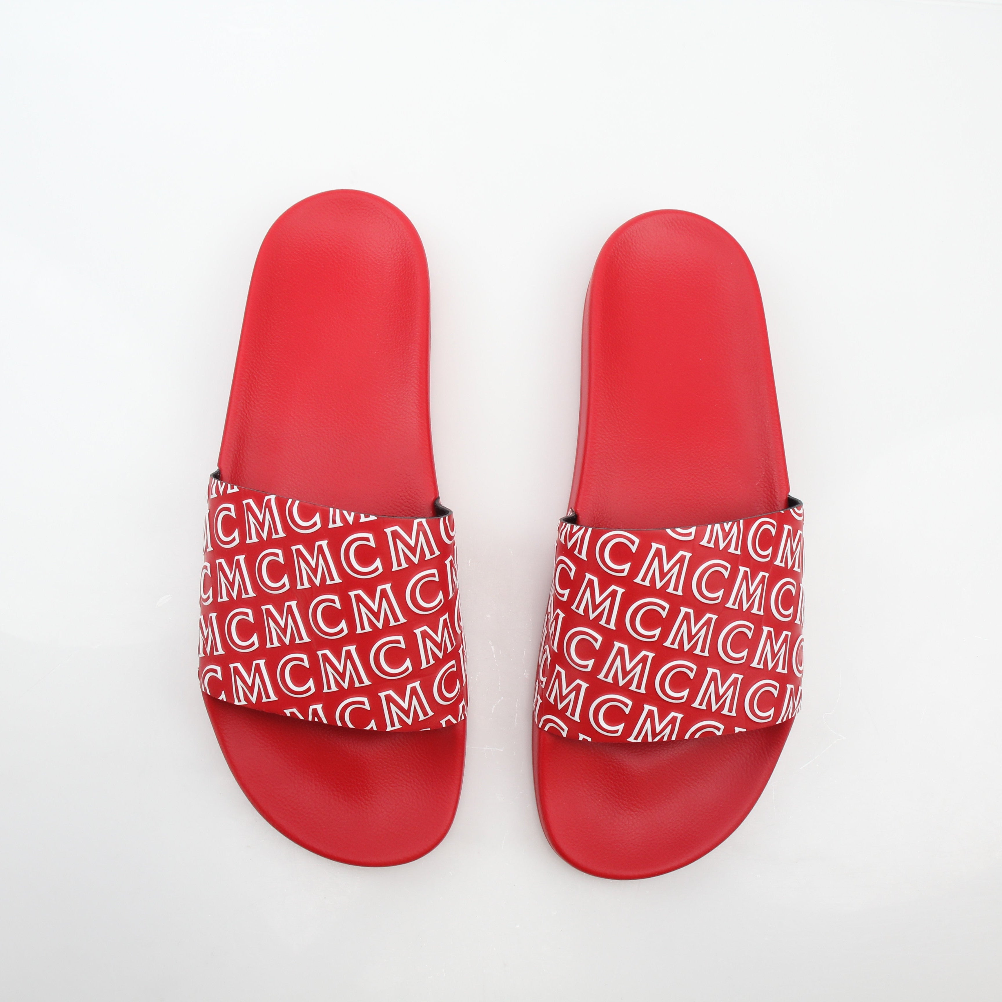 Gold & Beyond MCM red logo print slide sandals with open toe and wide straps, showcasing the brand's signature design.