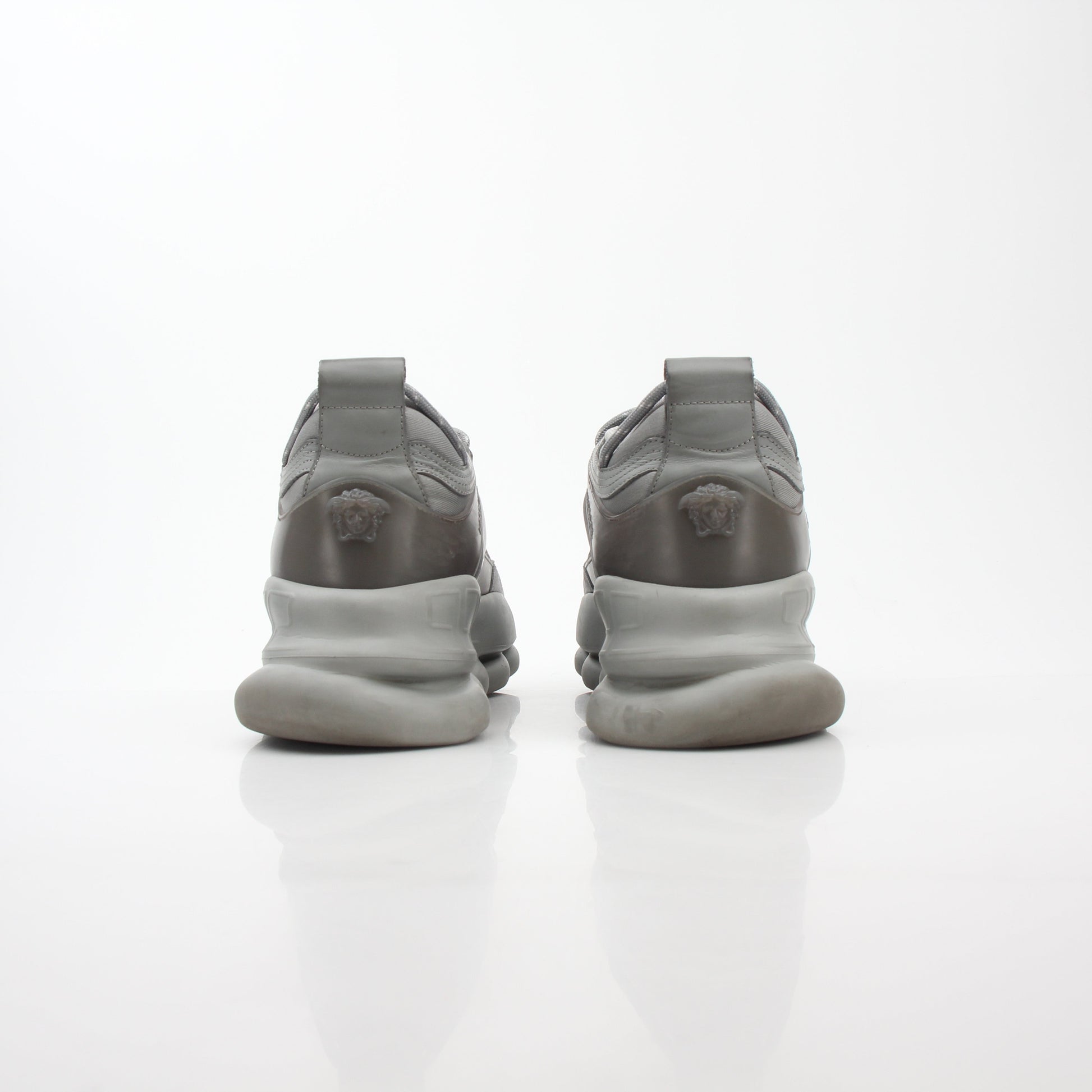 Gray Chain Reaction sneakers by Versace featuring stylish design and gold accents, placed on a white background.