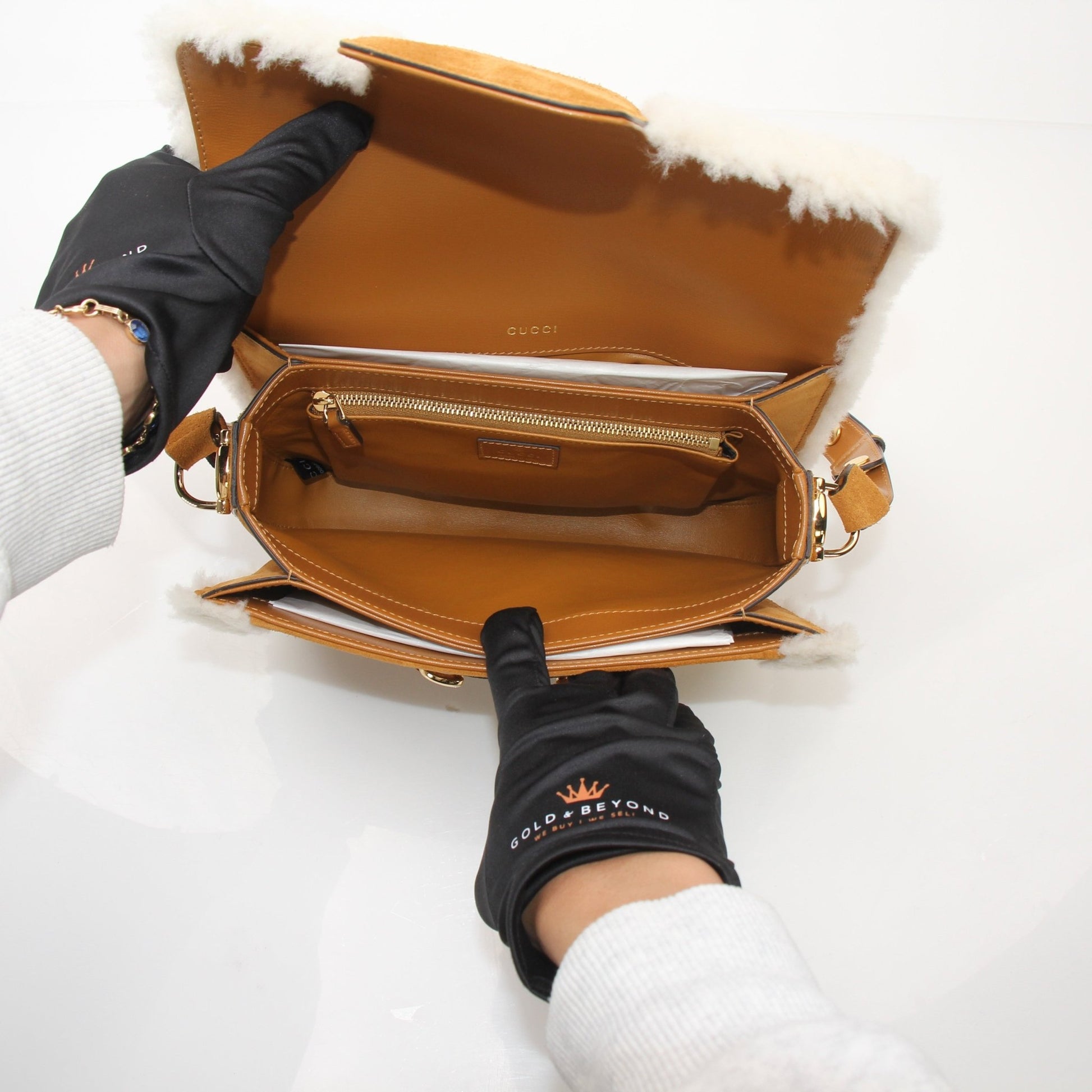 Gucci suede shearling Horsebit 1955 shoulder handbag with gold hardware and structured design, displayed on a neutral background.