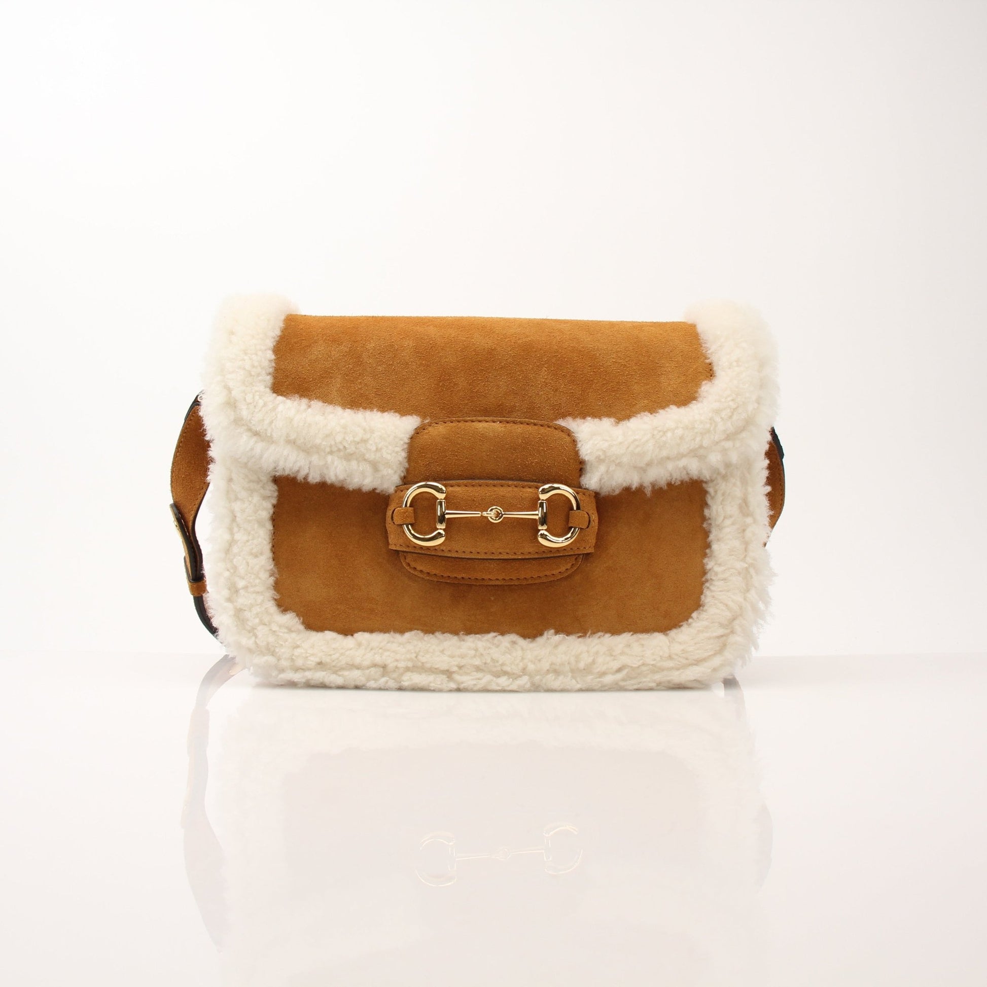 Gucci suede shearling Horsebit 1955 shoulder handbag with gold hardware and adjustable strap, stylish and luxurious accessory.
