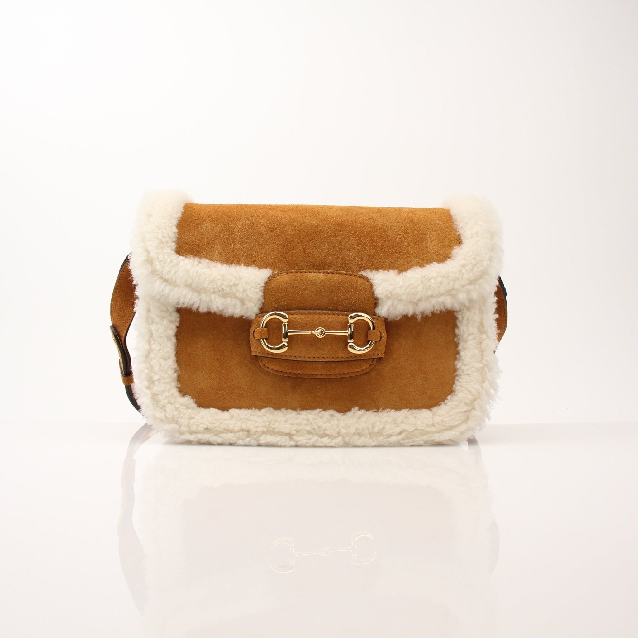 Gucci suede shearling Horsebit 1955 shoulder handbag with gold hardware and adjustable strap, stylish and luxurious accessory.