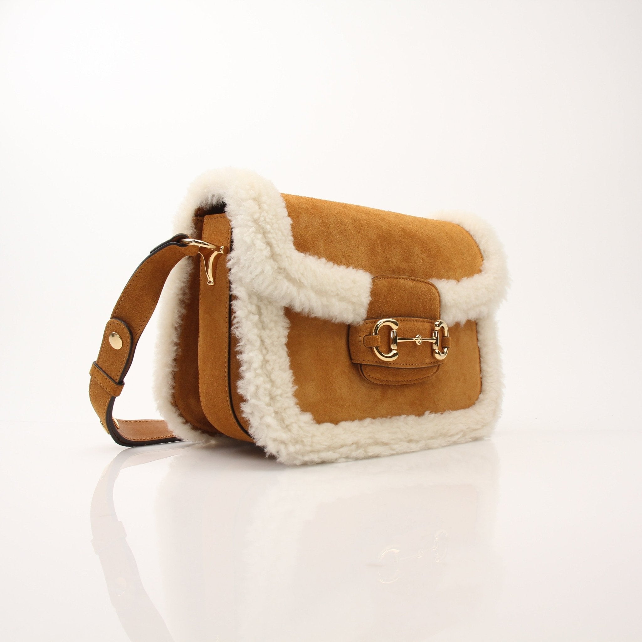 Gucci suede shearling Horsebit 1955 shoulder handbag with gold hardware and adjustable strap, stylish and luxurious fashion accessory.