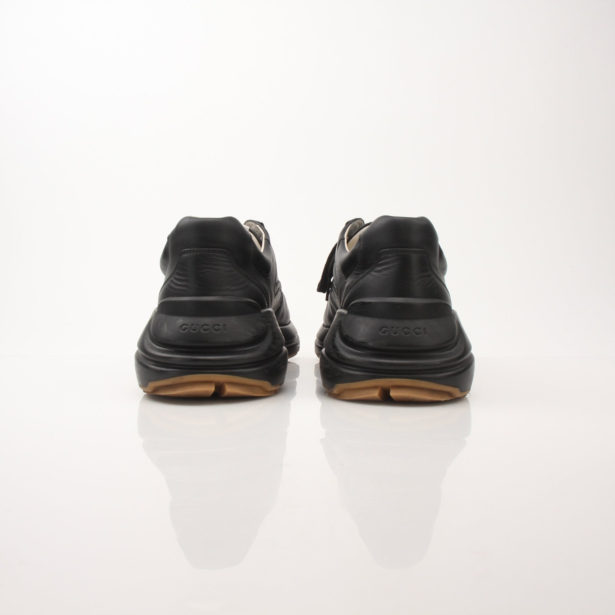 Iridescent Gucci men's Rython logo sneakers with sleek design and white rubber soles, displayed on a neutral background.