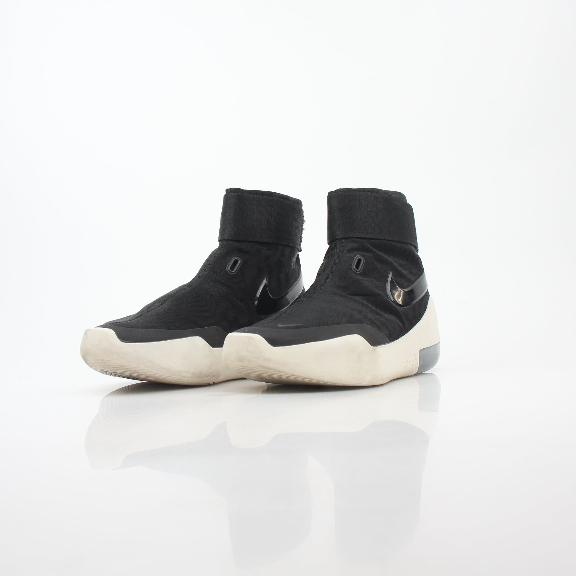 Black Nike x Fear of God Air Fear of God 1 high-top sneakers, showing sleek design and Nike branding on the shoes.